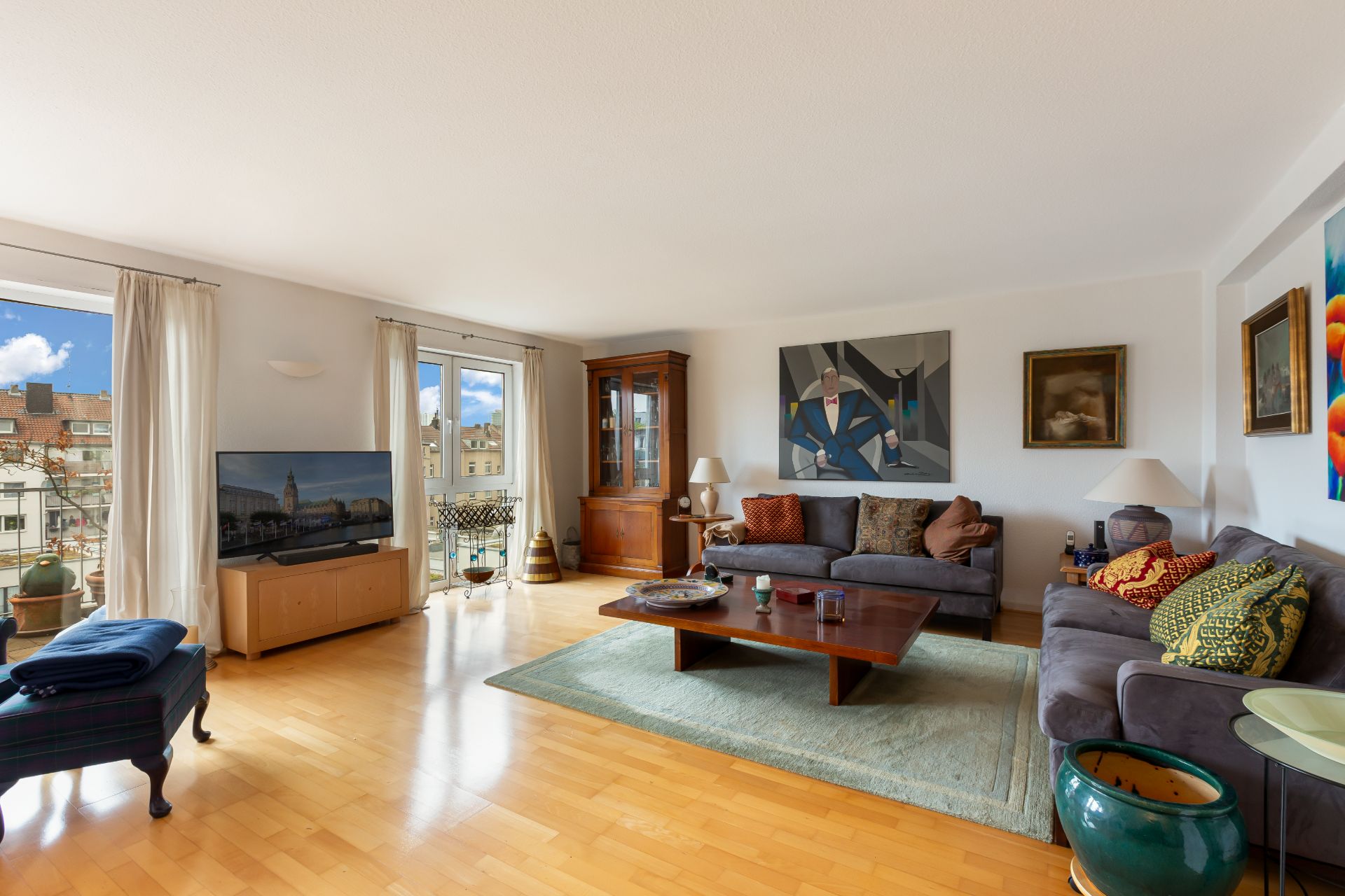 Helles Wohnzimmer mit zwei Sofas, Holzboden, Couchtisch, Teppich und großem Fenster.