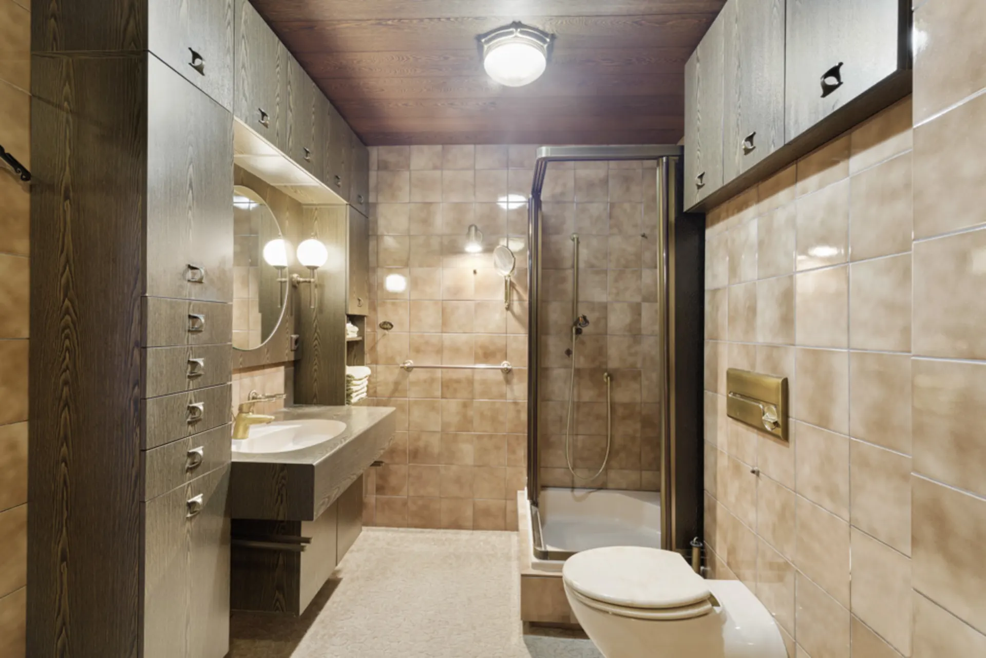 Badezimmer mit Duschkabine, Toilette, Waschbecken, Spiegel und Holzmöbeln.