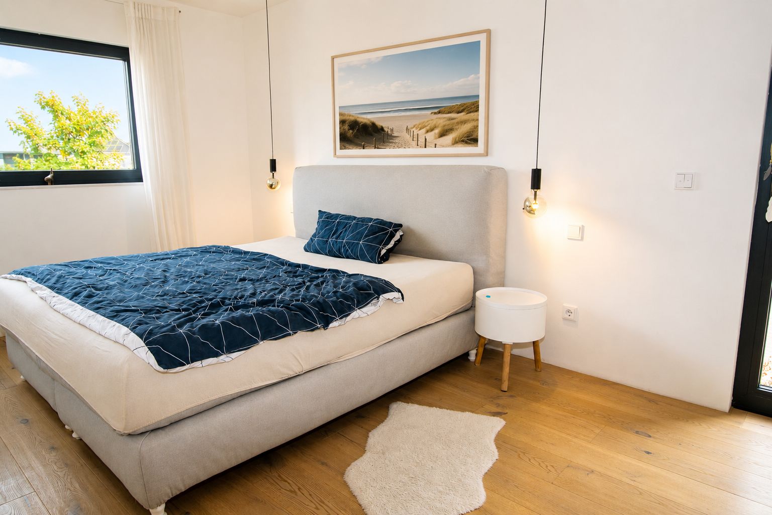 Modernes Schlafzimmer mit Doppelbett, Nachttisch, Fenster und Bild an der Wand.