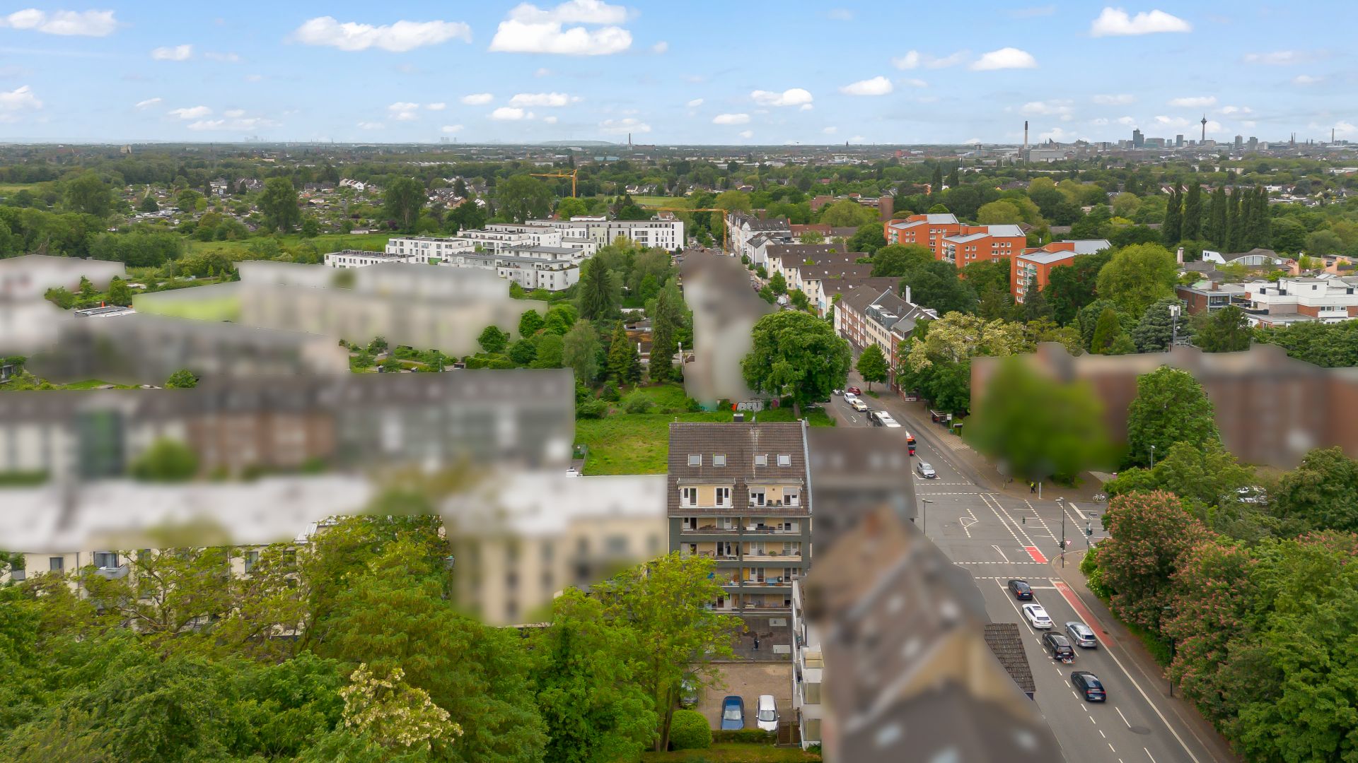 Luftaufnahme von Wohnhäusern, Straßen und vielen Bäumen in einem Wohngebiet.