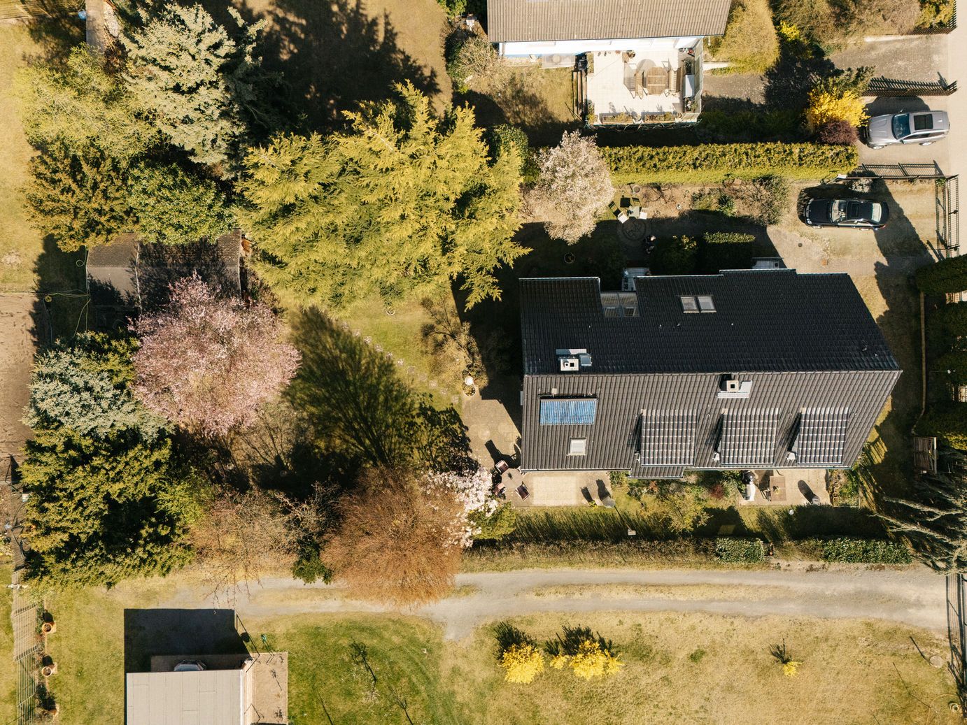 Vogelperspektive auf ein Haus mit Garten und umliegenden Bäumen.