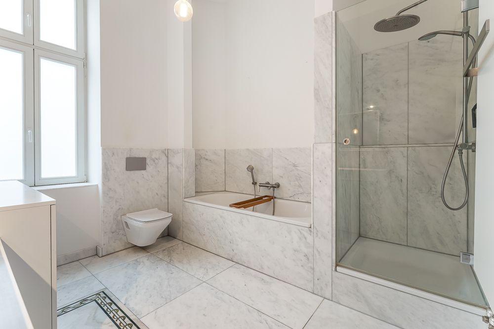 Modernes Badezimmer mit Badewanne, Dusche, WC und großem Fenster.