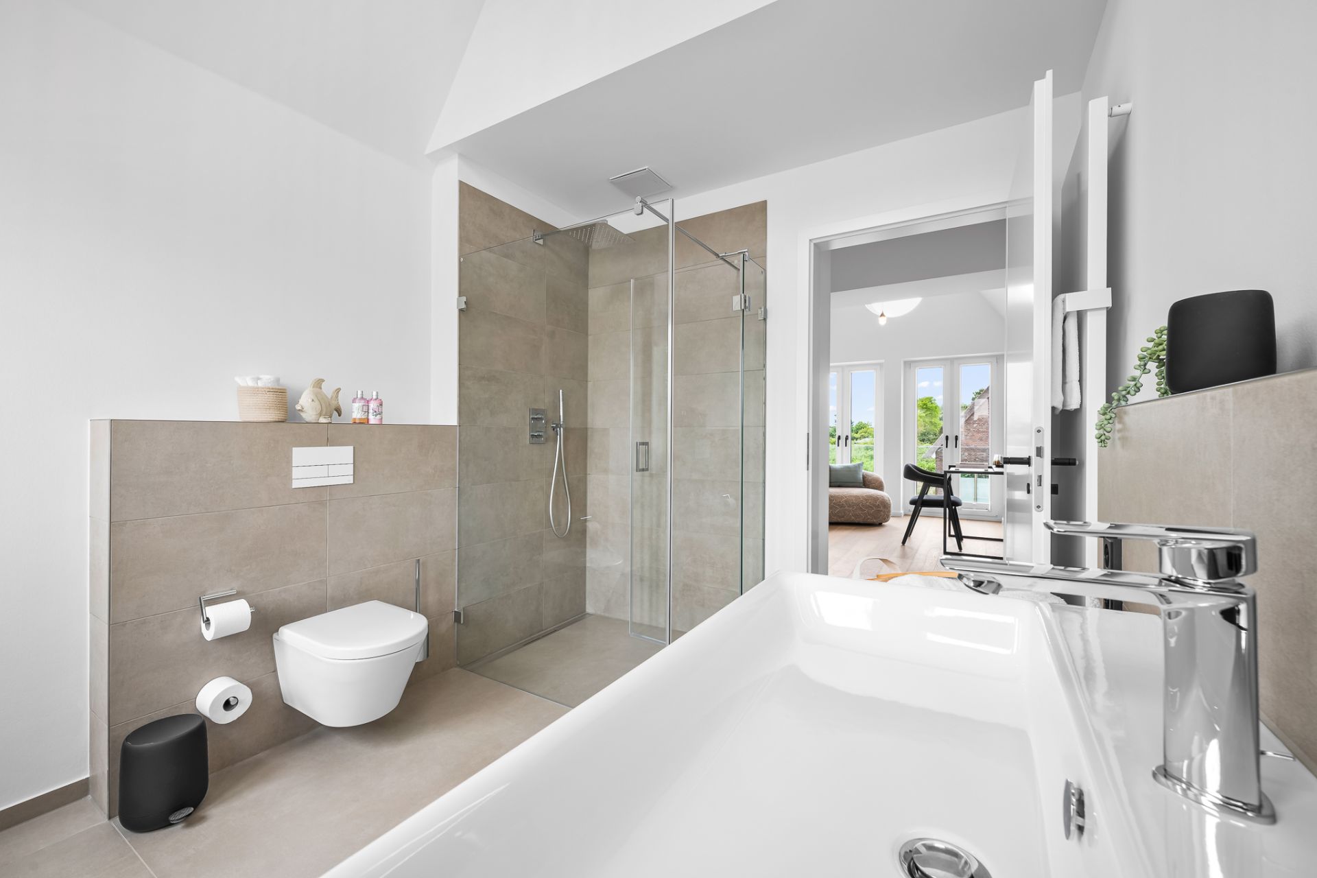 Modernes Badezimmer mit Dusche, Toilette und Badewanne, Blick in ein helles Wohnzimmer.