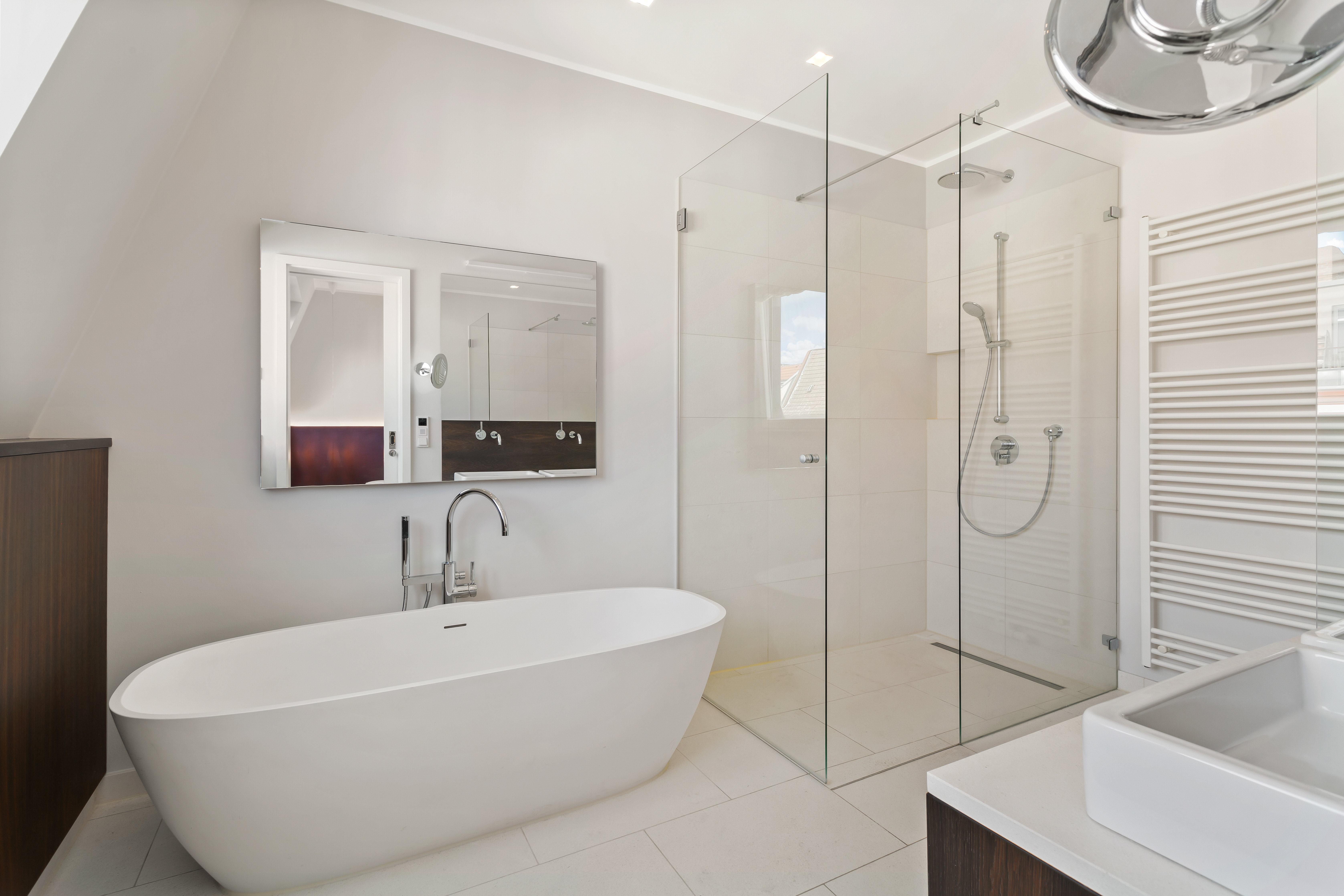 Modernes Badezimmer mit freistehender Badewanne, großer Dusche und Wandspiegel.