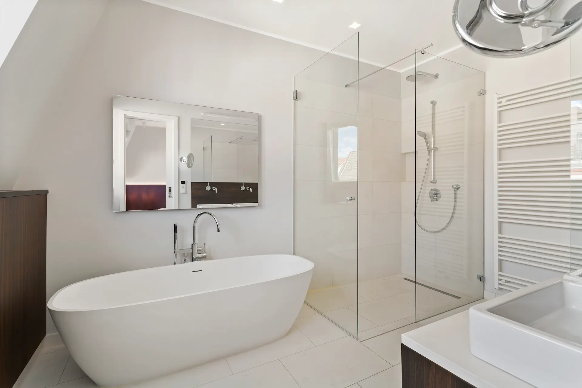Modernes Badezimmer mit freistehender Badewanne, großer Dusche und Wandspiegel.