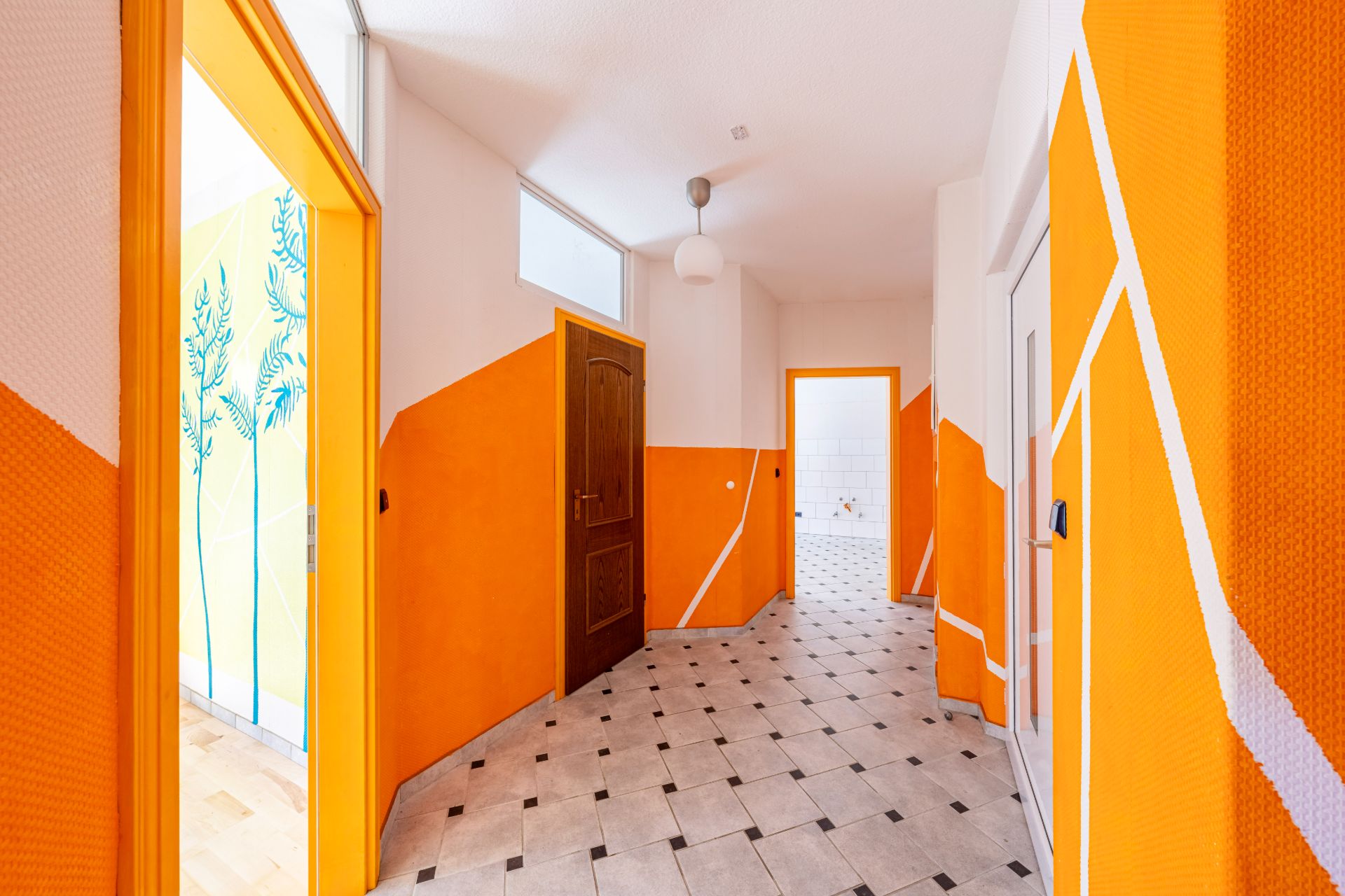Heller Flur mit orange-weißen Wänden, Türen zu mehreren Zimmern und gefliestem Boden.