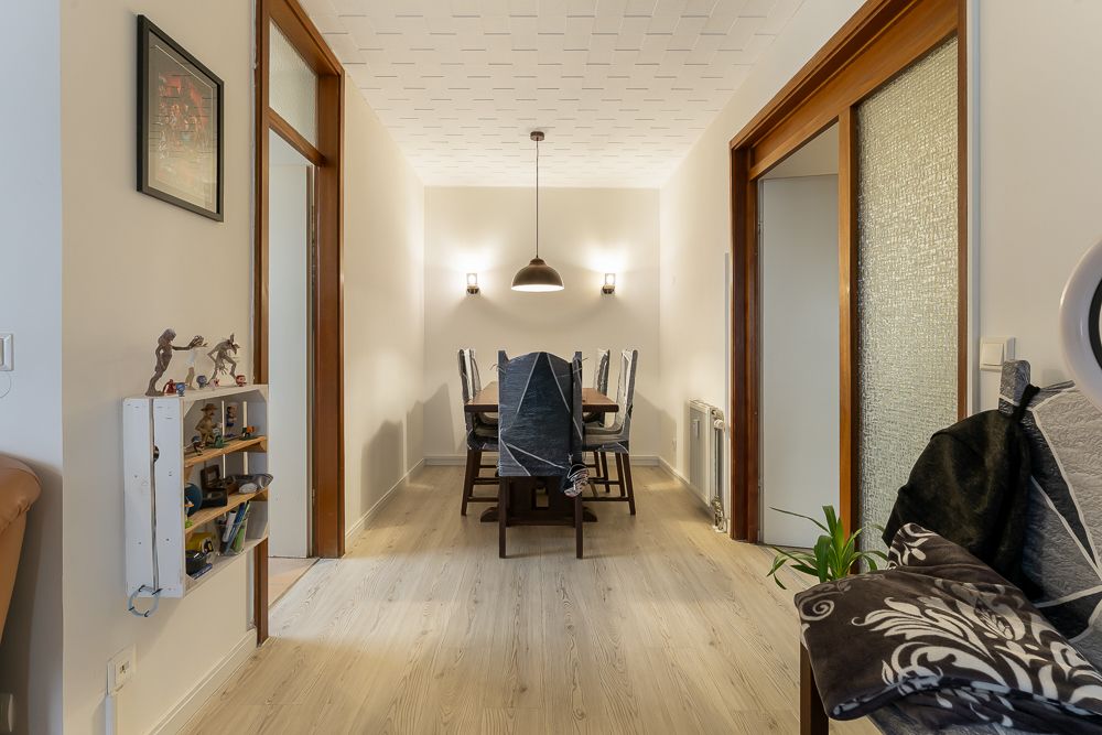 Esszimmer mit Holztisch, sechs Stühlen und Deckenleuchte, flankiert von zwei Wandleuchten.
