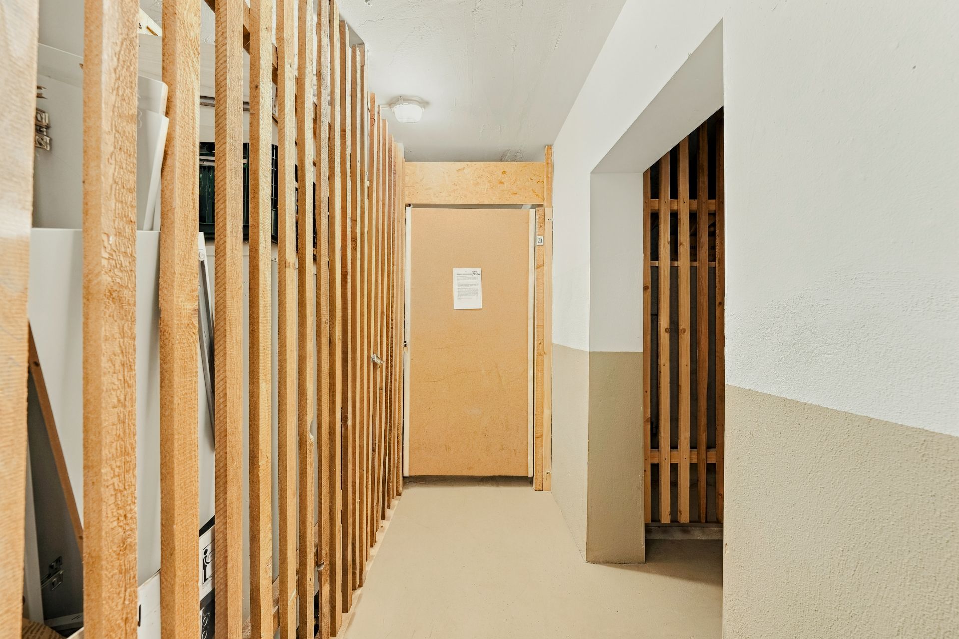 Flur mit Holzgitterwänden und Abstellräumen in einem Wohnhaus.