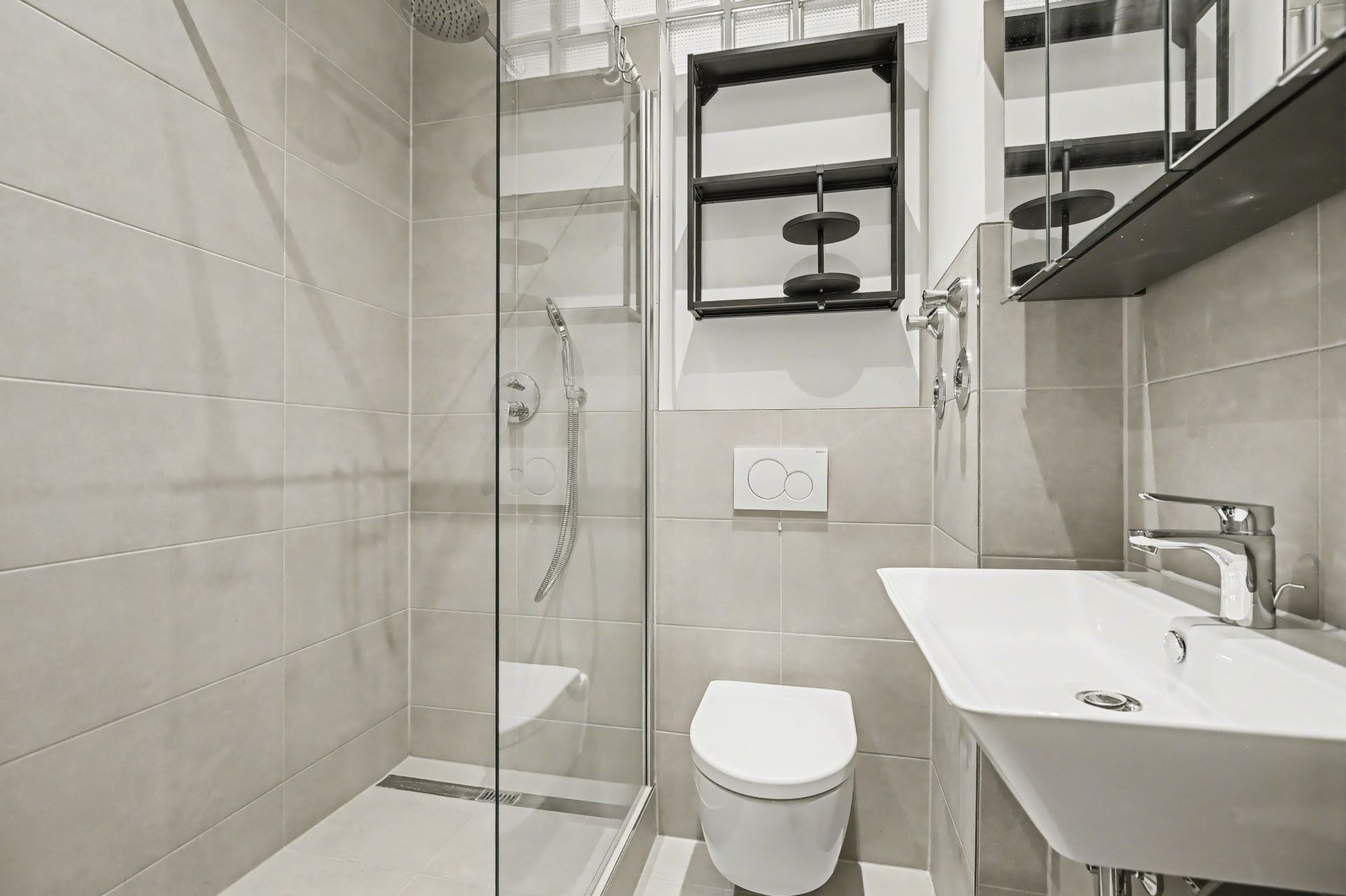 Modernes Badezimmer mit Dusche, Wandtoilette, Waschbecken und Spiegelschrank.