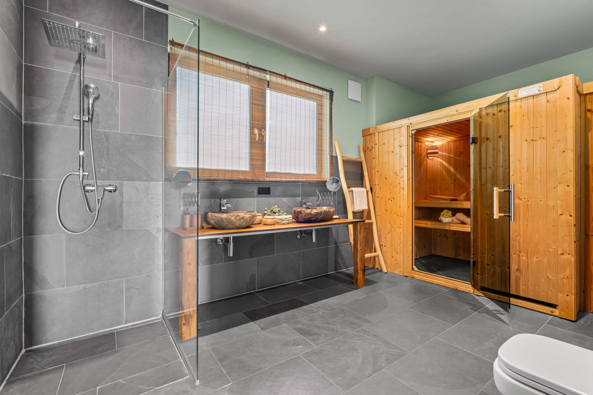Modernes Badezimmer mit großer Dusche, Doppelwaschbecken, Holzsauna und Fenster.
