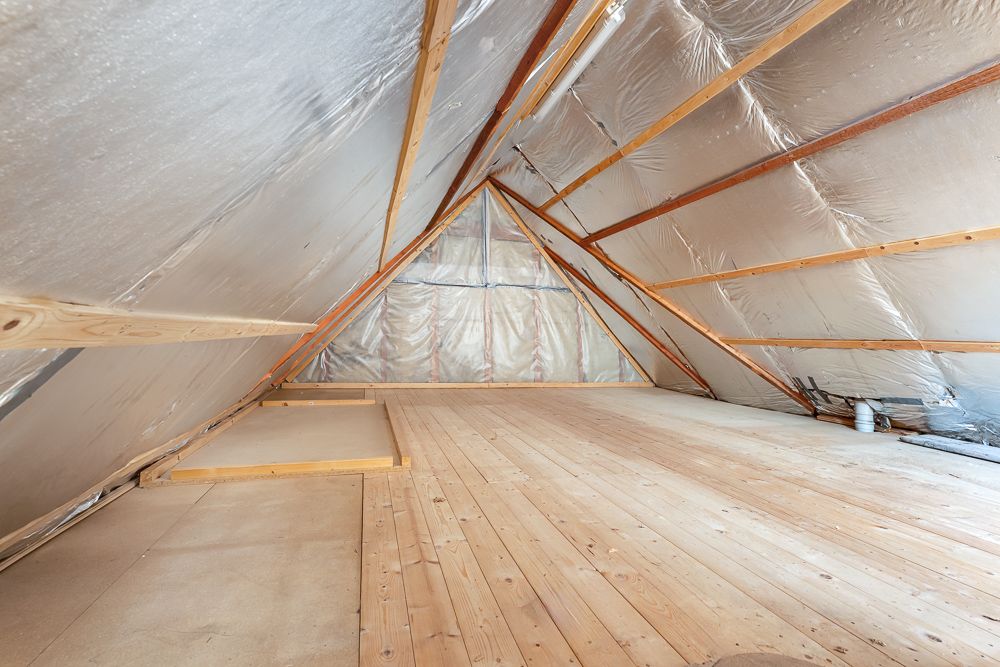 Ausgebauter Dachboden mit Holzfußboden und Dämmung an den Wänden.