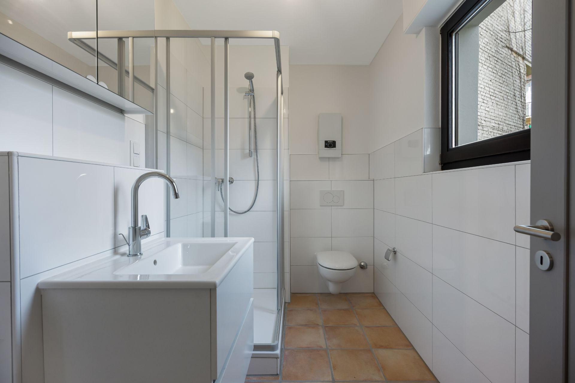 Modernes Bad mit Dusche, Waschbecken, WC und Fenster, weiße Fliesen und Fliesenboden.