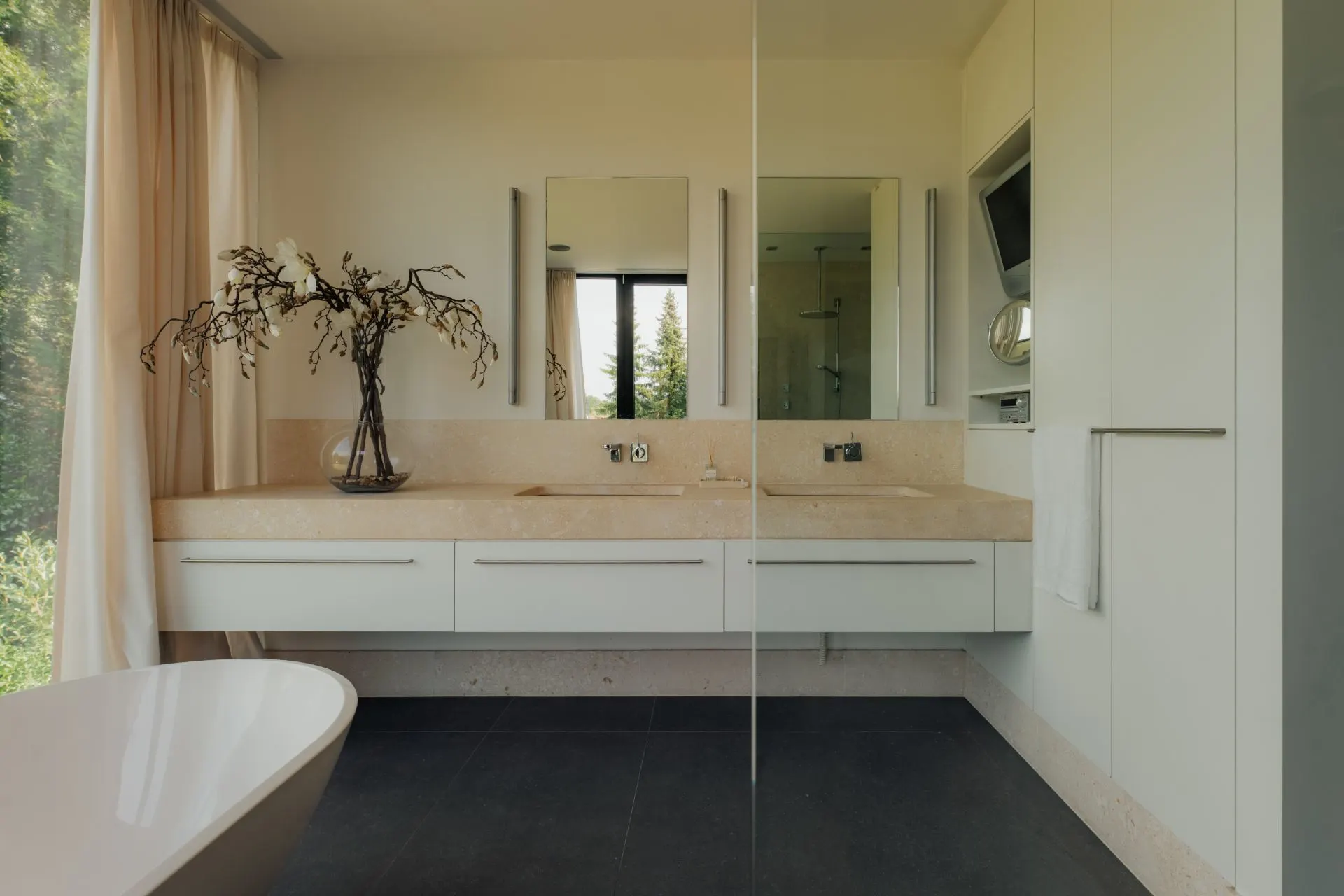 Modernes Badezimmer mit Doppelwaschbecken und großem Spiegel, daneben eine Badewanne.