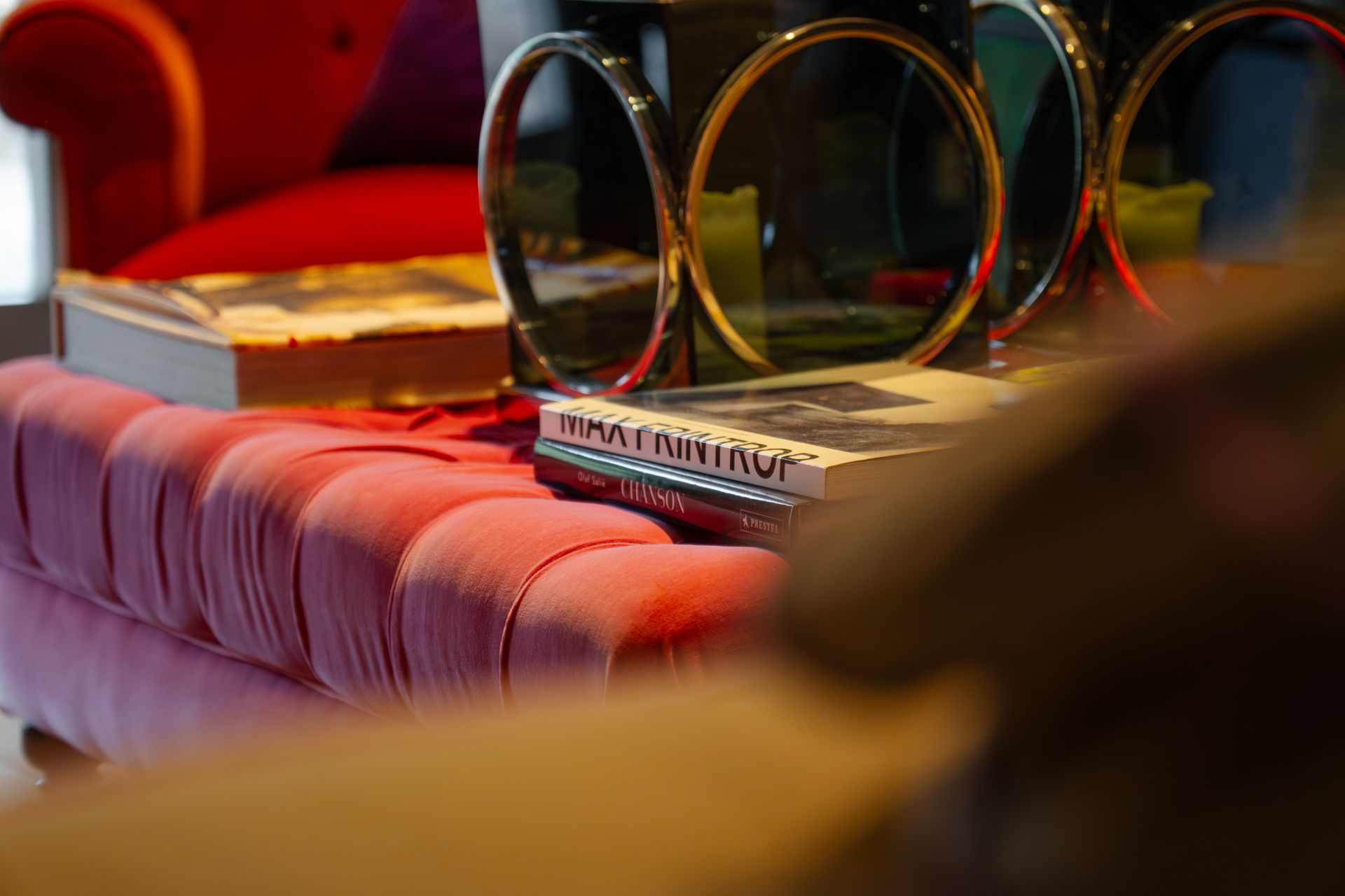 Ein rotes, gepolstertes Sofa mit Büchern und Dekoration auf einem Couchtisch davor.
