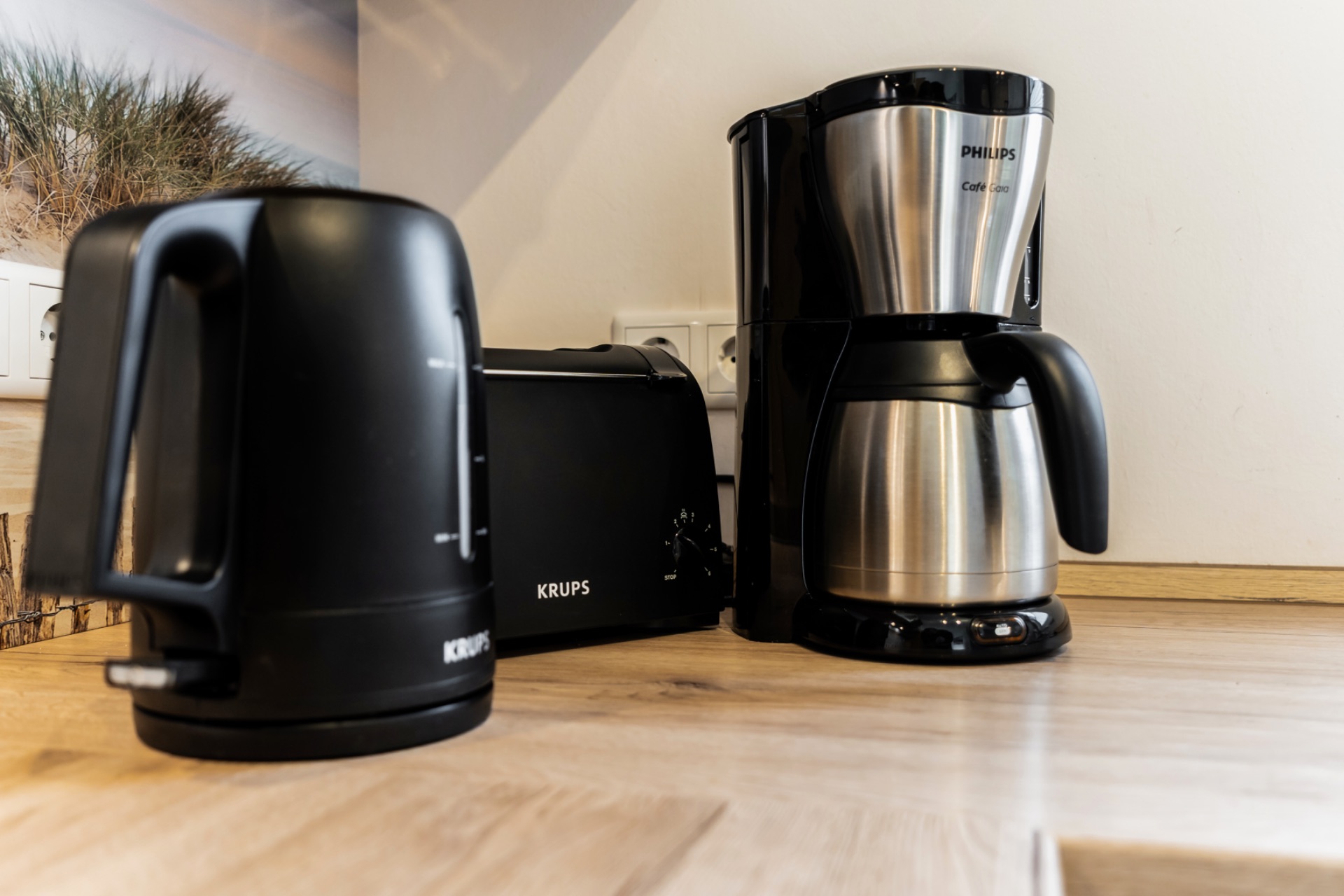 Wasserkocher, Toaster und Kaffeemaschine auf einer Küchenarbeitsplatte.