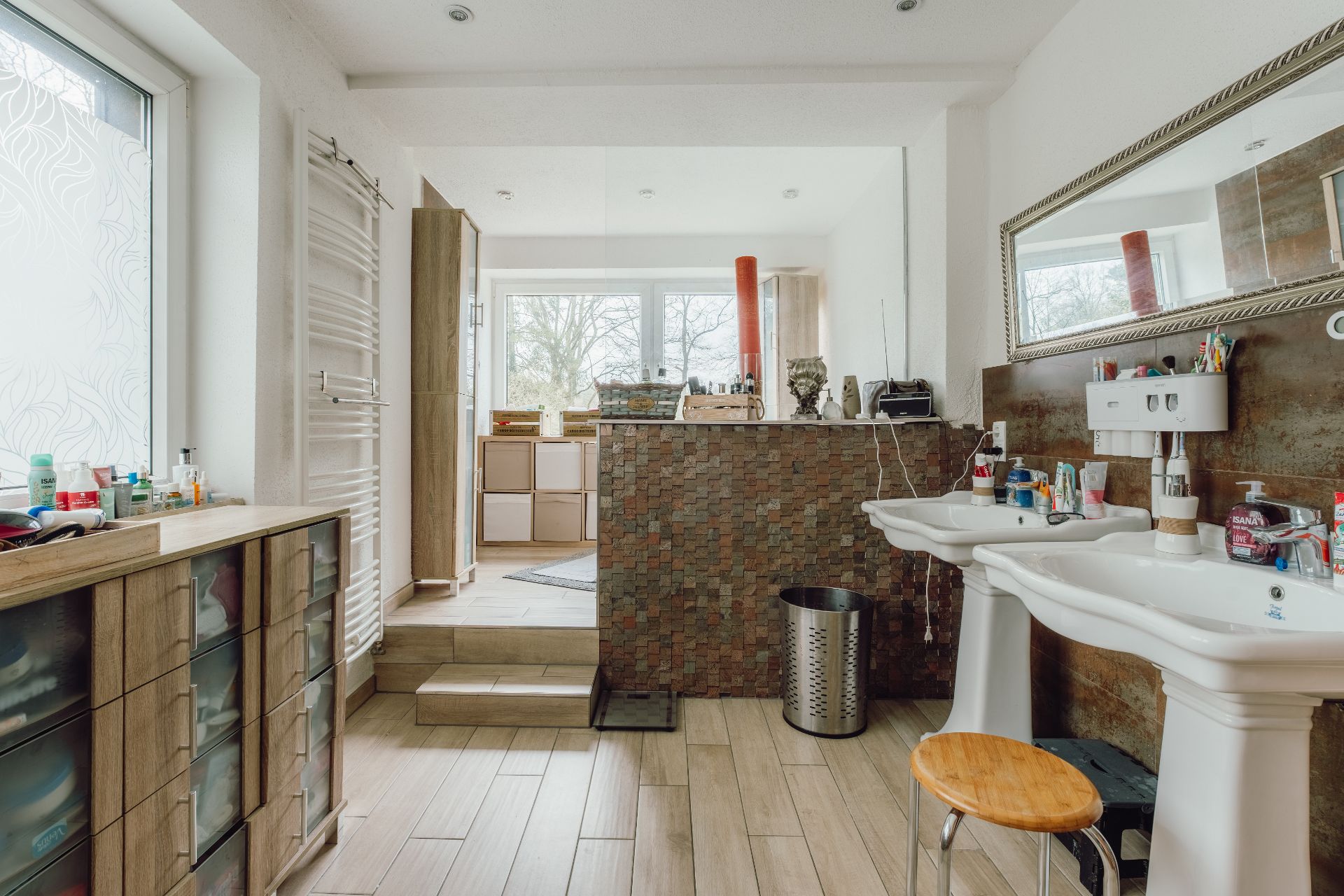Modernes Badezimmer mit zwei Waschbecken, großem Spiegel und Fenster mit Sichtschutzfolie.