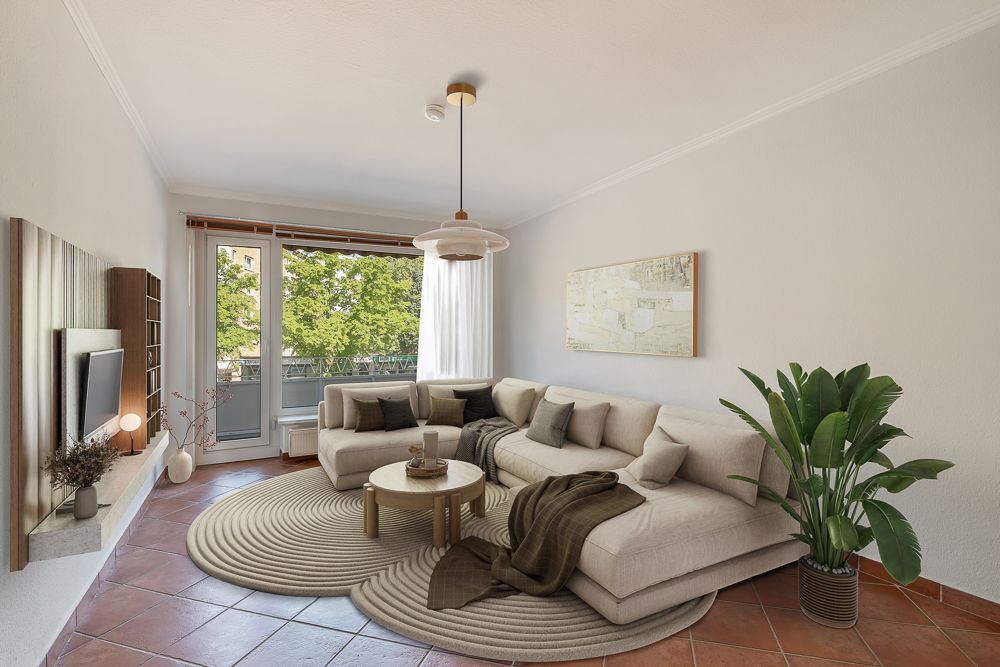 Helles Wohnzimmer mit Ecksofa, rundem Teppich, Couchtisch, großer Pflanze und Balkonzugang.