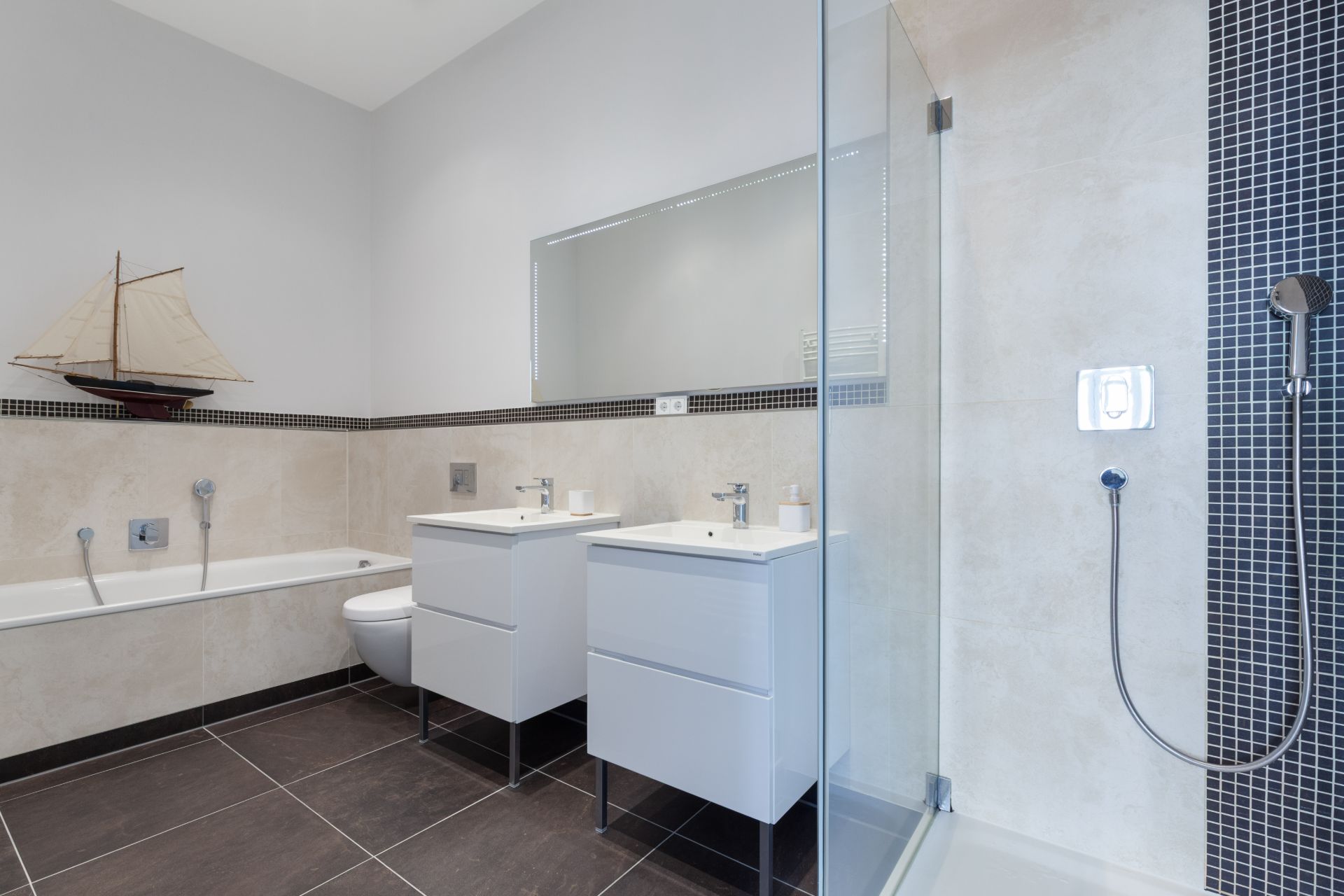 Modernes Badezimmer mit Badewanne, zwei Waschbecken und Glasdusche.