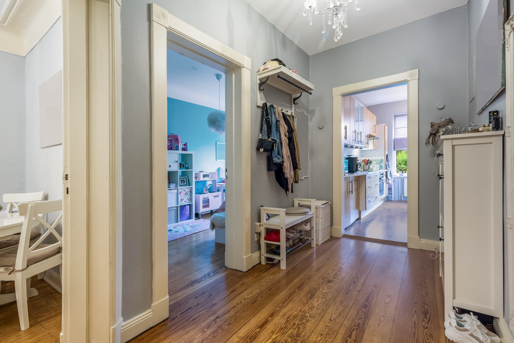 Flur einer Wohnung mit Blick in ein Kinderzimmer, eine Küche und einen Essbereich.