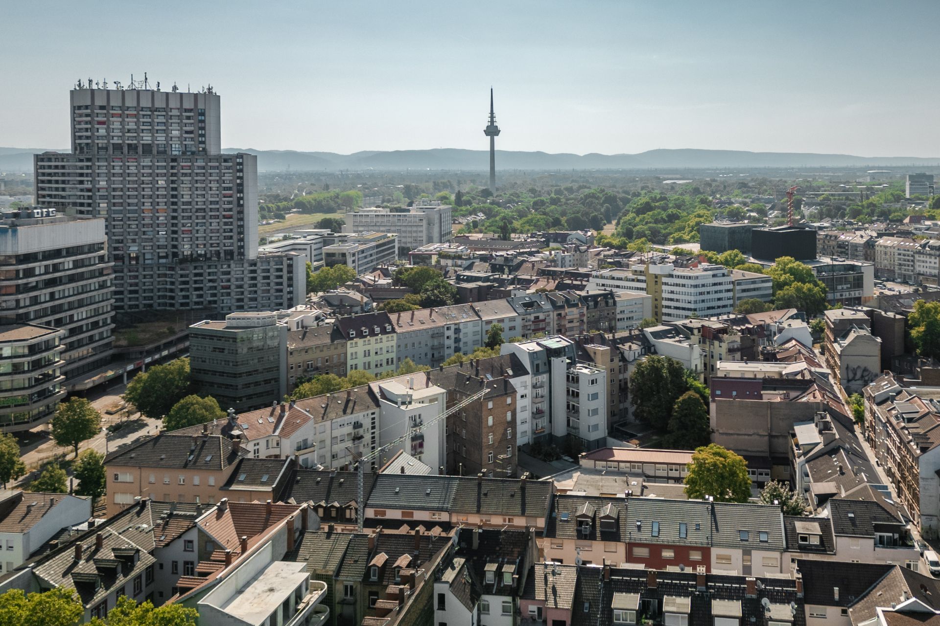 Blick auf eine Wohngegend mit vielen Mehrfamilienhäusern und einem Fernsehturm im Hintergrund.