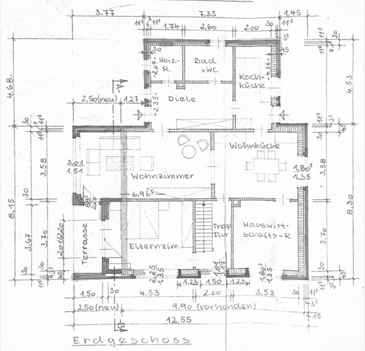 Grundriss des Erdgeschosses eines Wohnhauses mit Wohnzimmer, Küche und Terrasse.