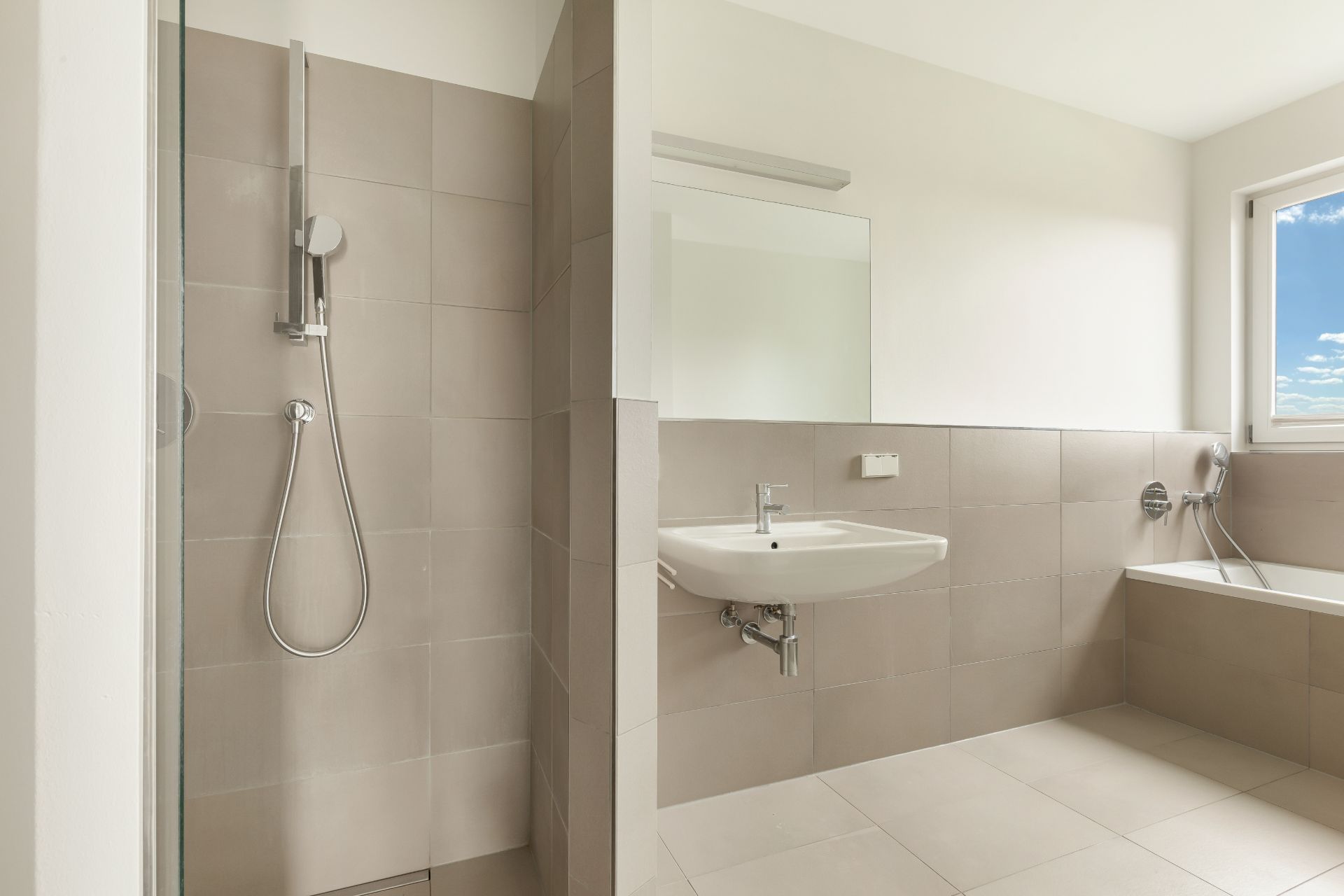 Modernes Badezimmer mit offener Dusche, Waschbecken, Badewanne und Fenster.