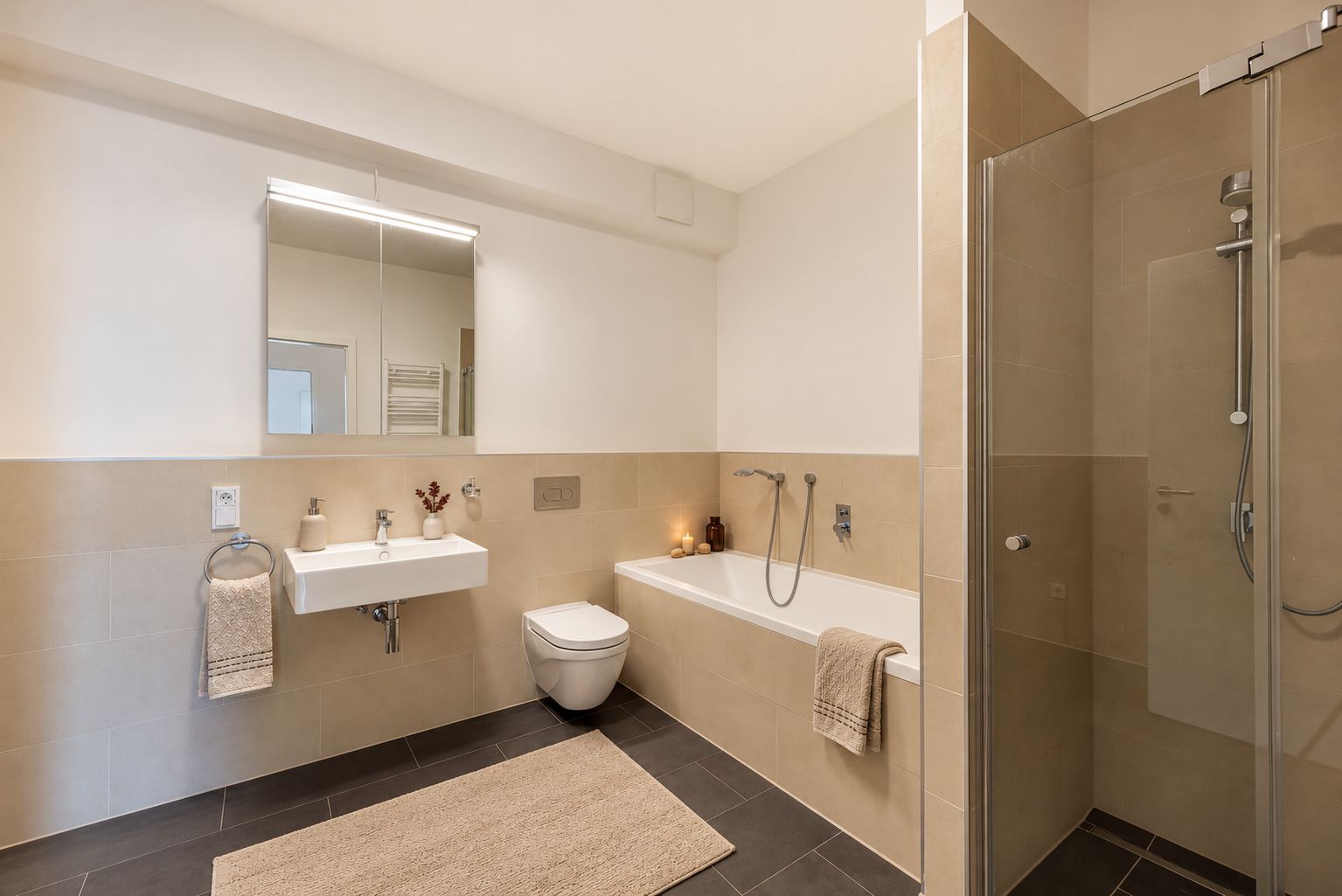 Modernes Badezimmer mit Badewanne, Dusche, Waschbecken, Spiegel und WC.