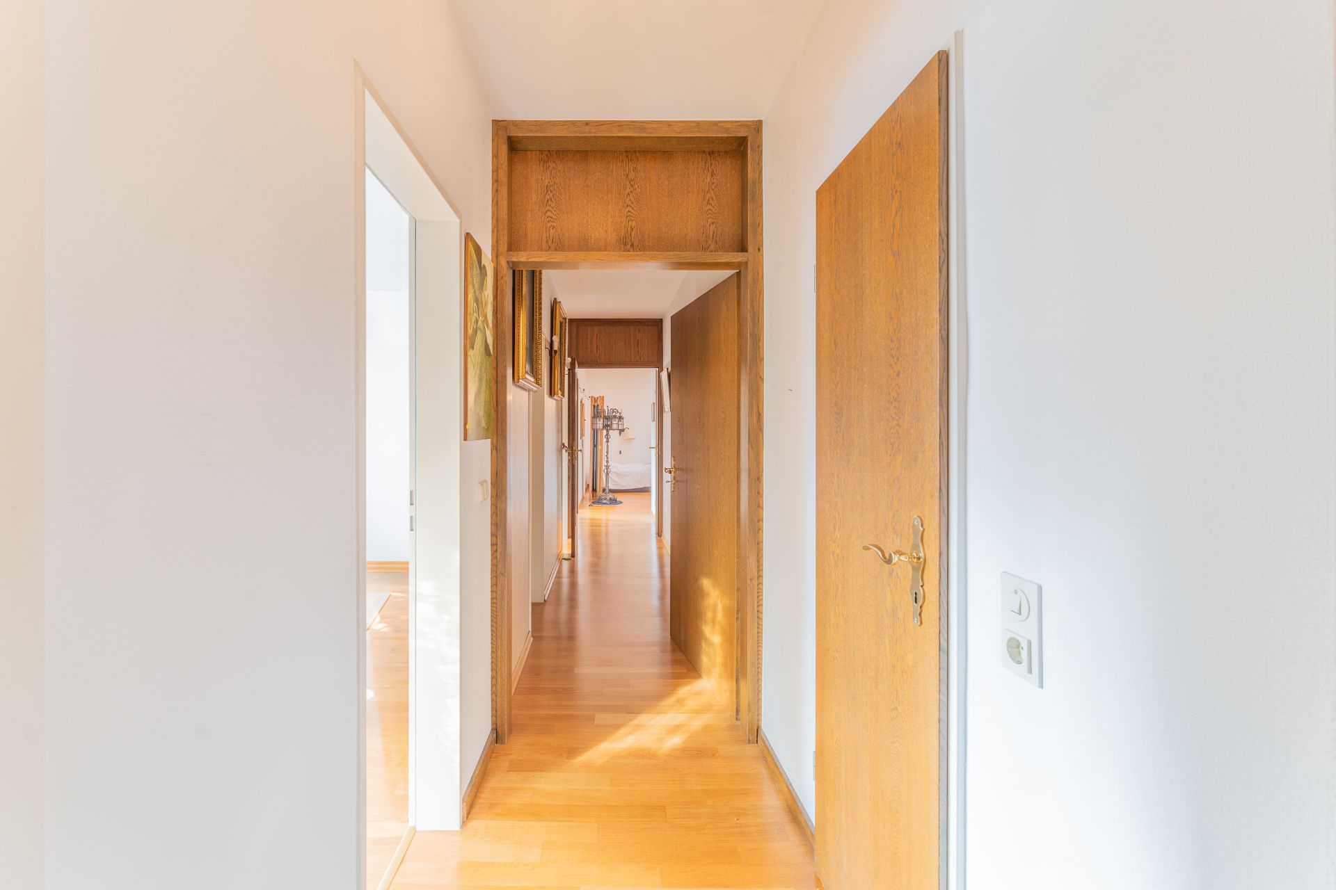 Heller Flur mit Holzboden und mehreren Holztüren in einer Wohnung.