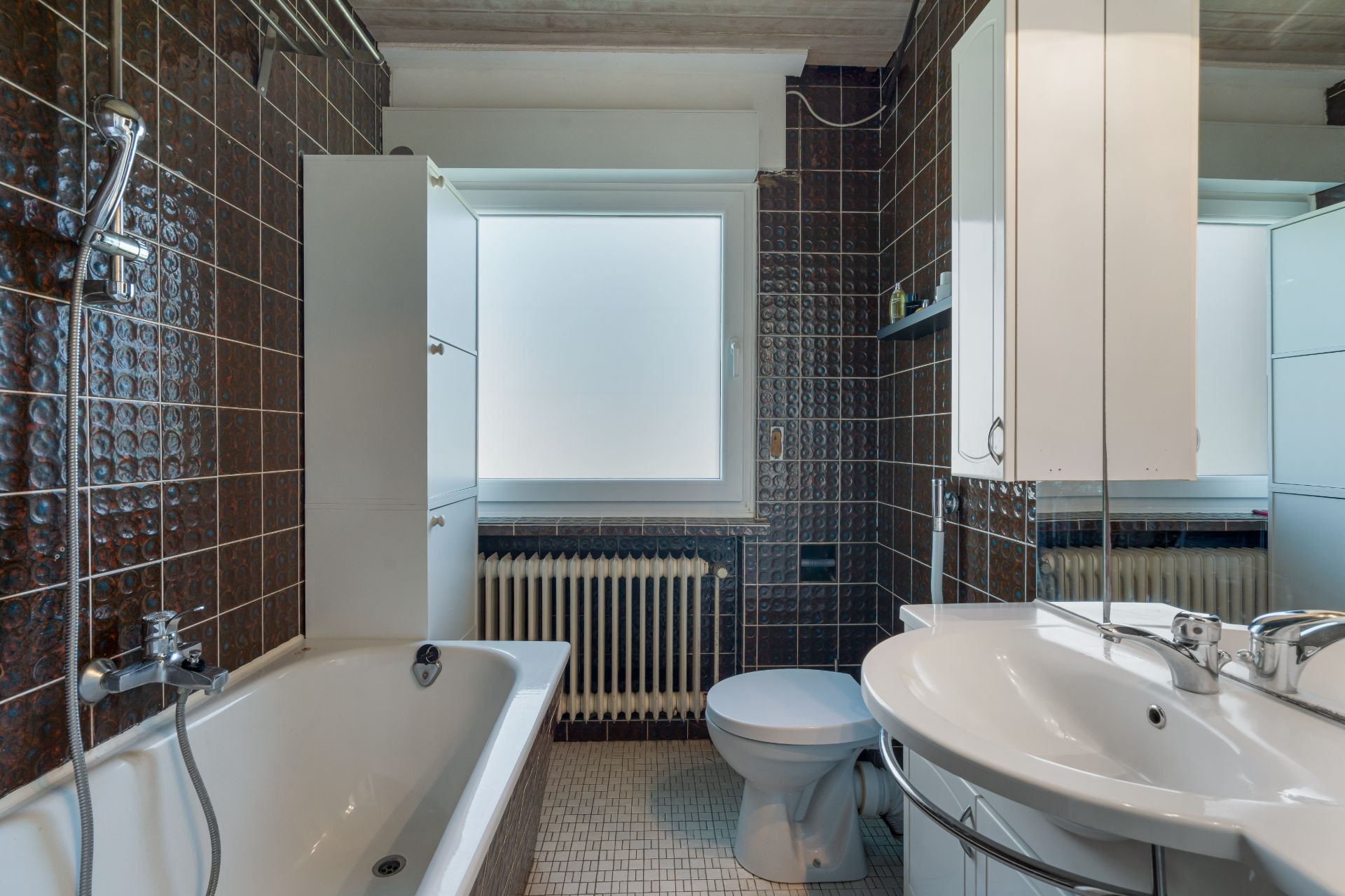 Modernes Badezimmer mit Badewanne, Waschbecken, Toilette und Fenster.