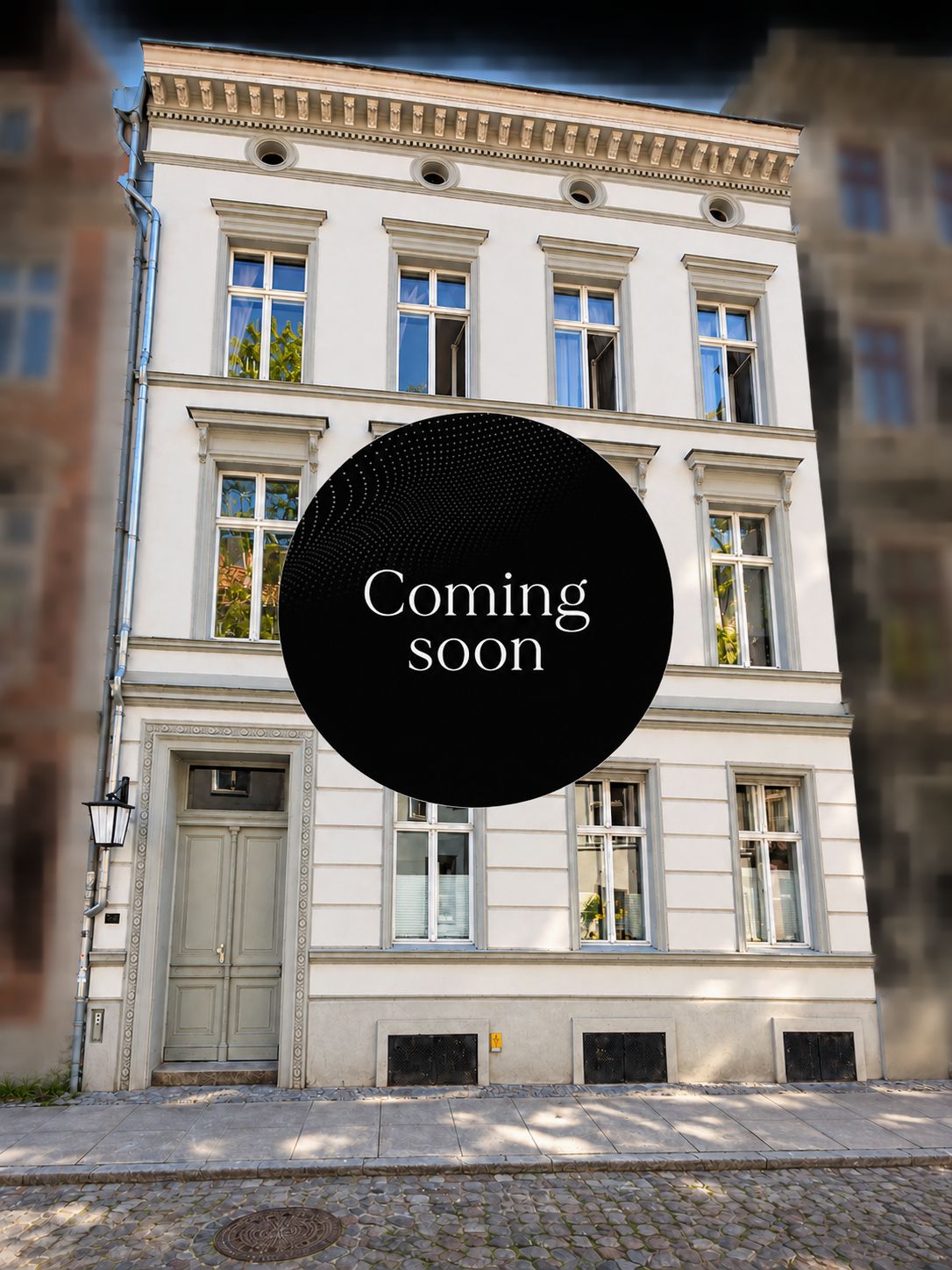 Fassade eines dreistöckigen Wohnhauses mit mehreren Fenstern und Haustür, Kreis mit 'Coming soon' in der Mitte.