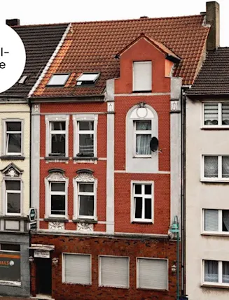 Drei mehrstöckige Wohnhäuser mit unterschiedlichen Fassaden in einer Stadtstraße.