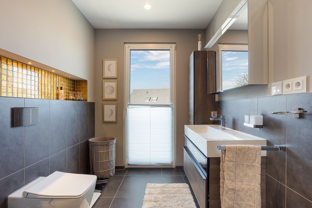 Modernes Badezimmer mit großem Fenster, Doppelwaschbecken und Wandtoilette.