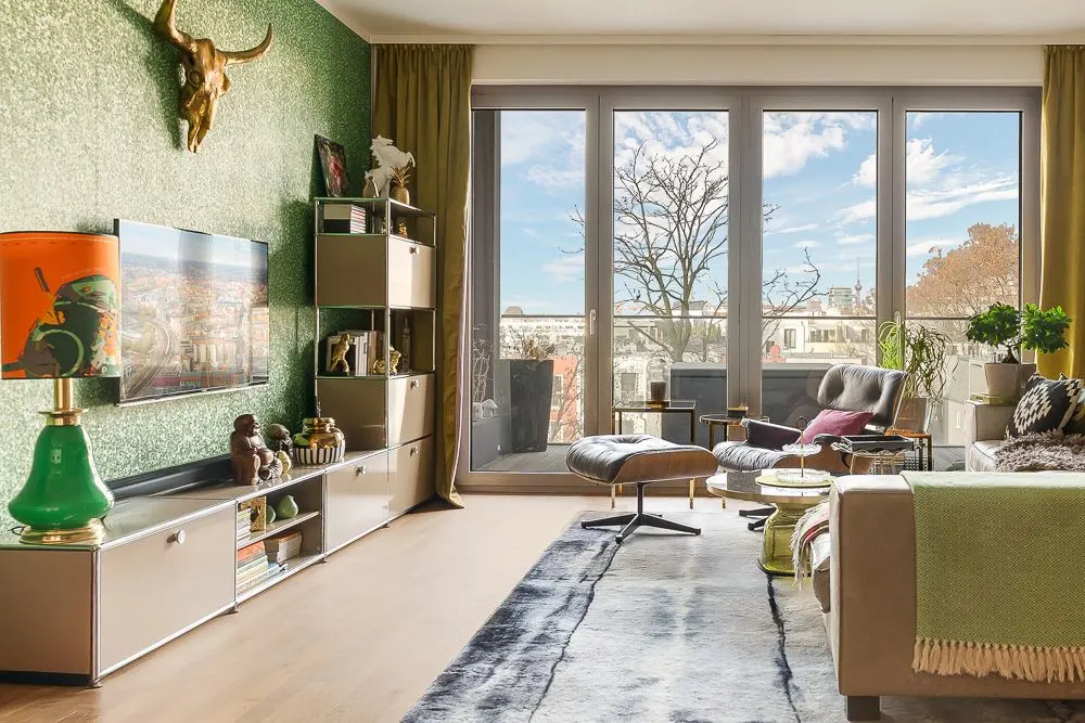 Helles Wohnzimmer mit großem Fenster, modernen Möbeln und dekorativer Wand mit Schädel.