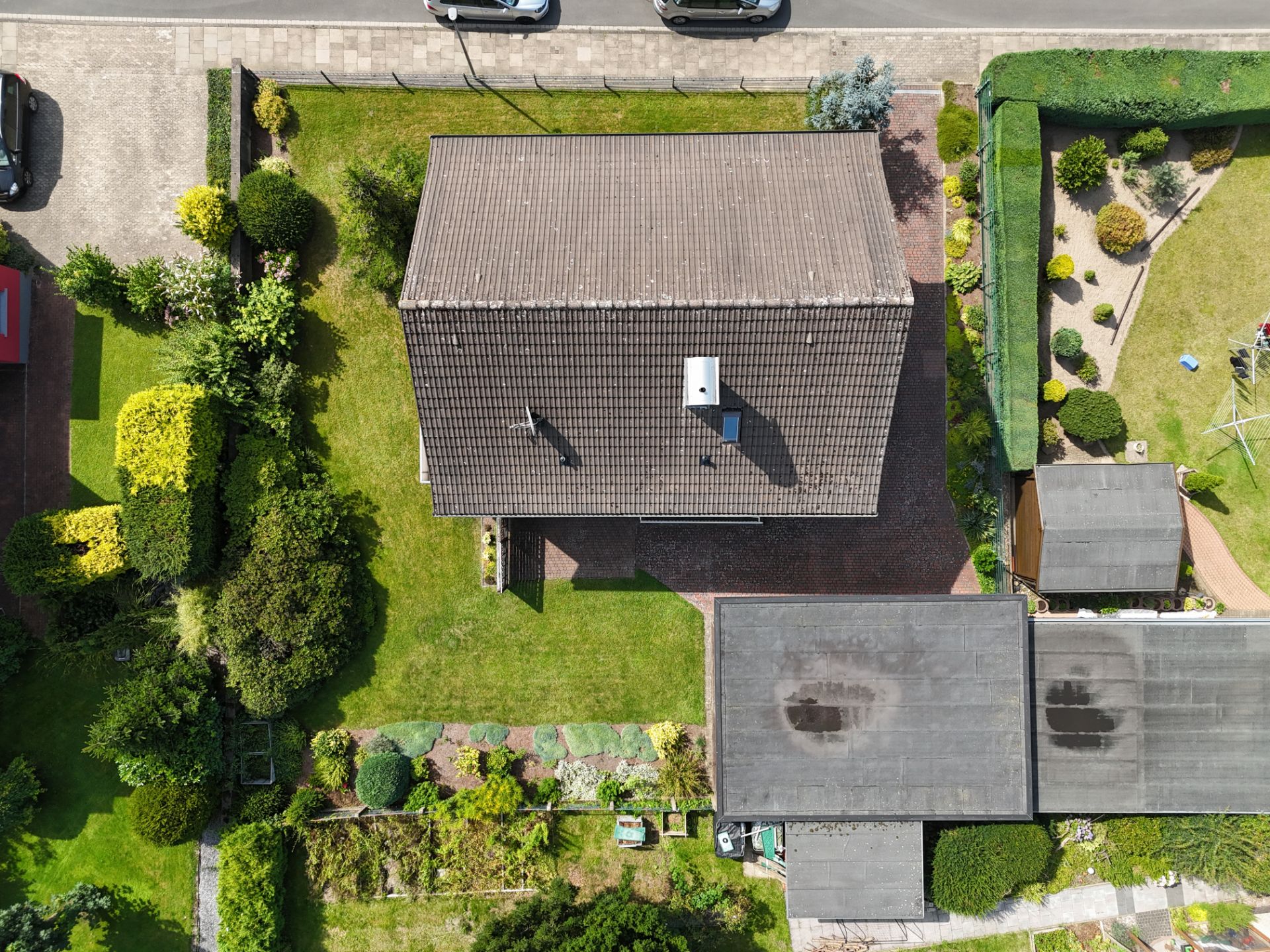 Luftaufnahme eines Einfamilienhauses mit Garten und Garage.