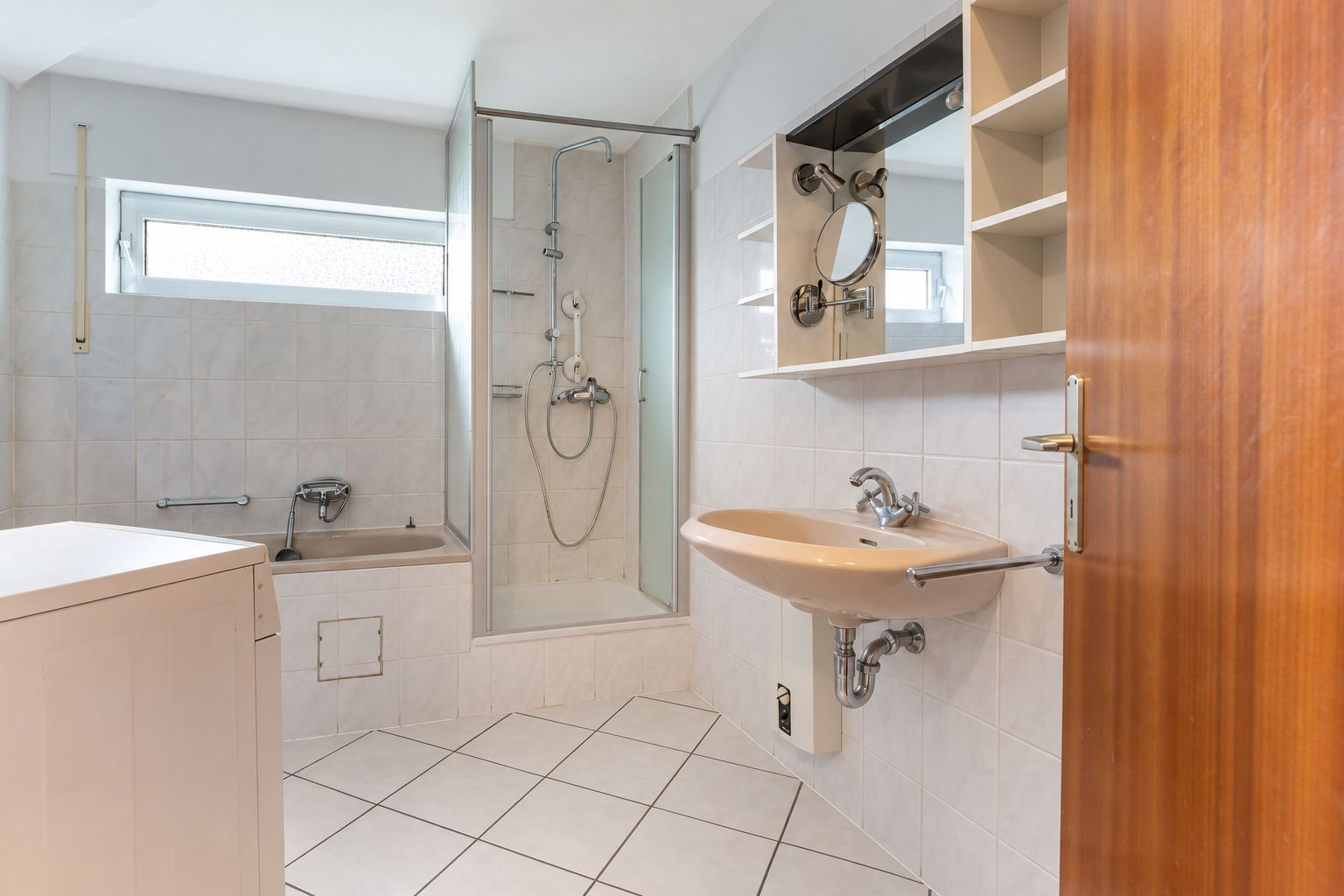 Helles Badezimmer mit Dusche, Badewanne, Waschbecken und Spiegelschrank.