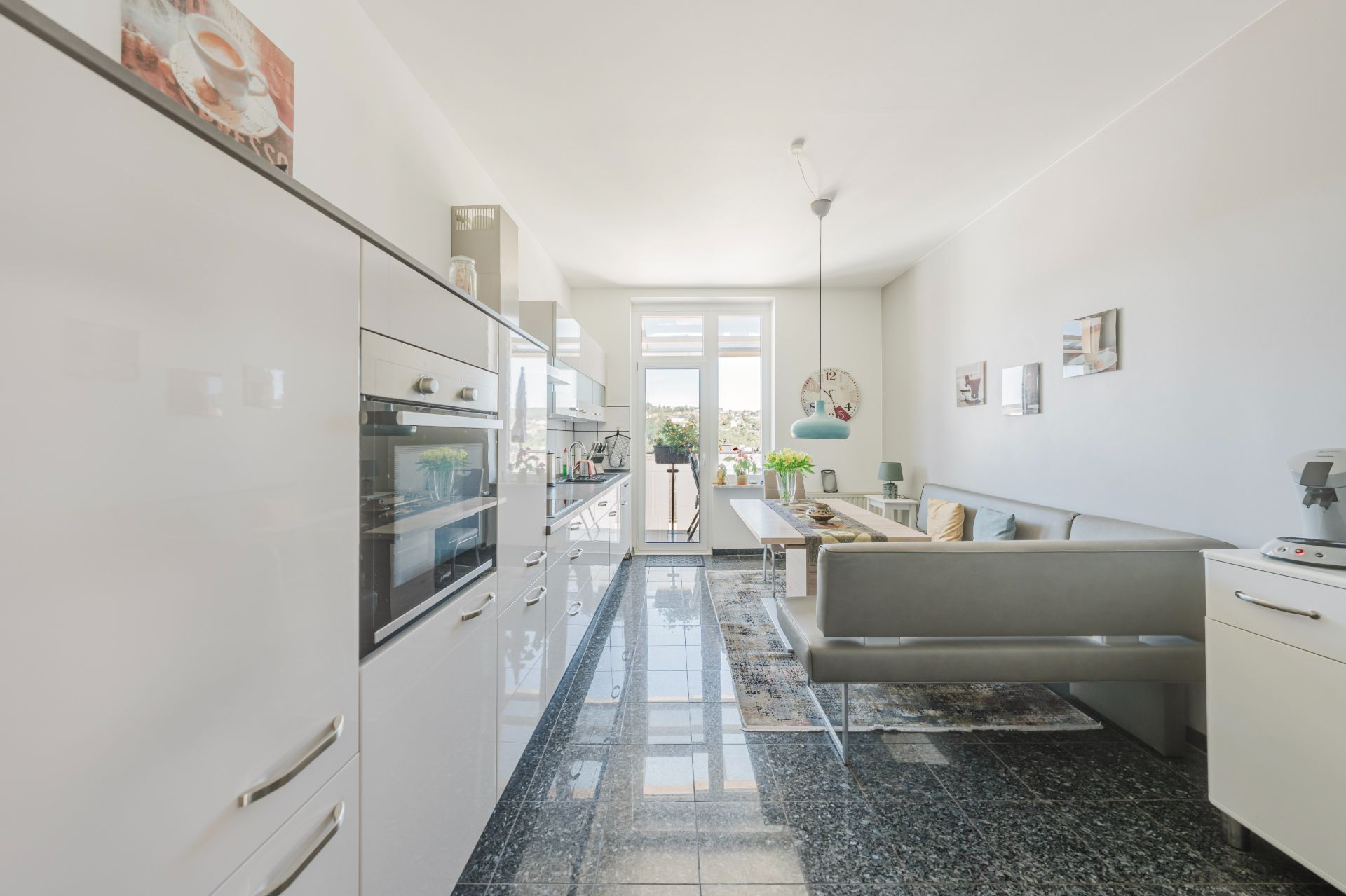 Moderne Wohnküche mit Einbauküche, Esstisch und großer Fensterfront.