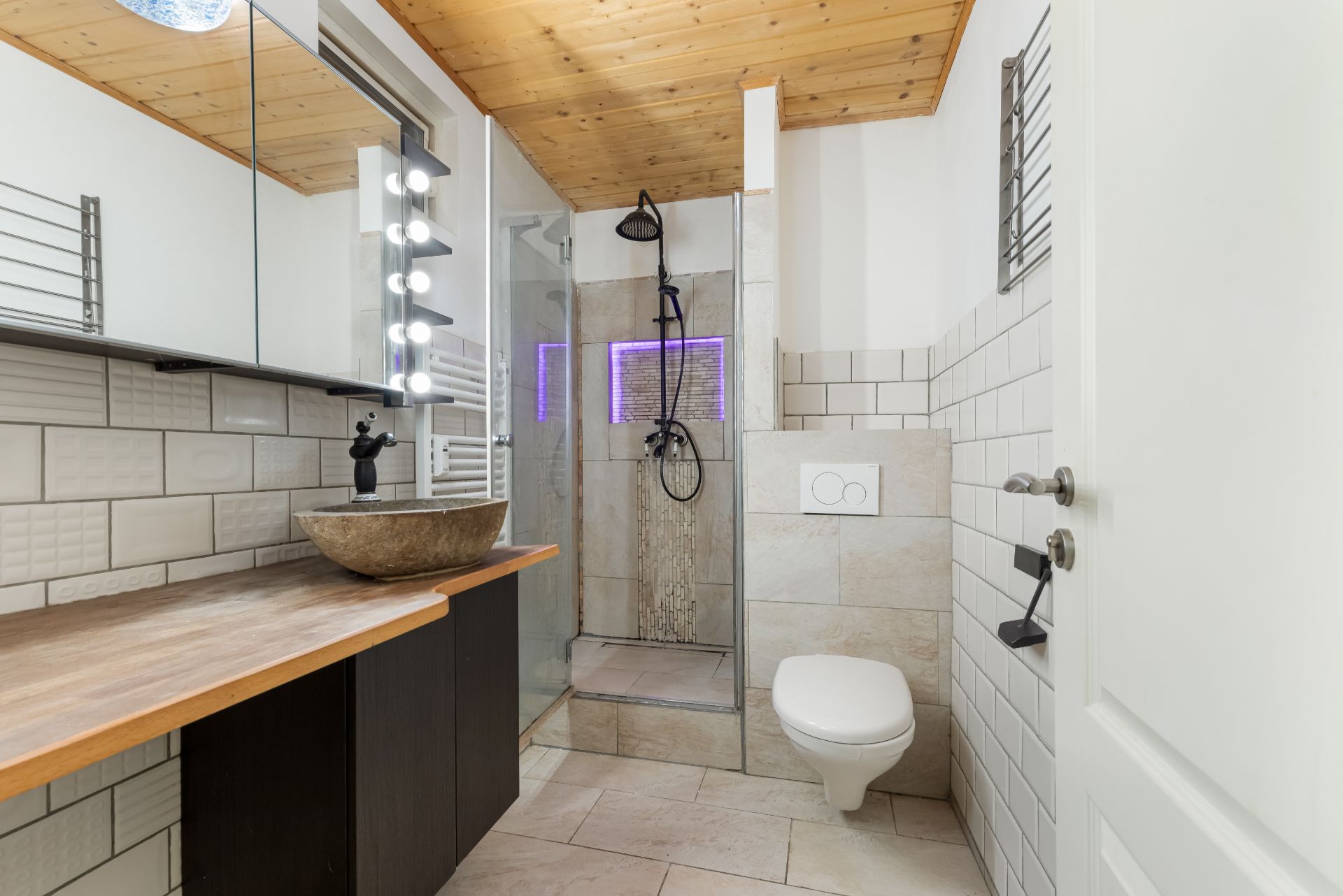 Modernes Badezimmer mit Holzdecke, ebenerdiger Dusche und Waschbecken auf Holzplatte.