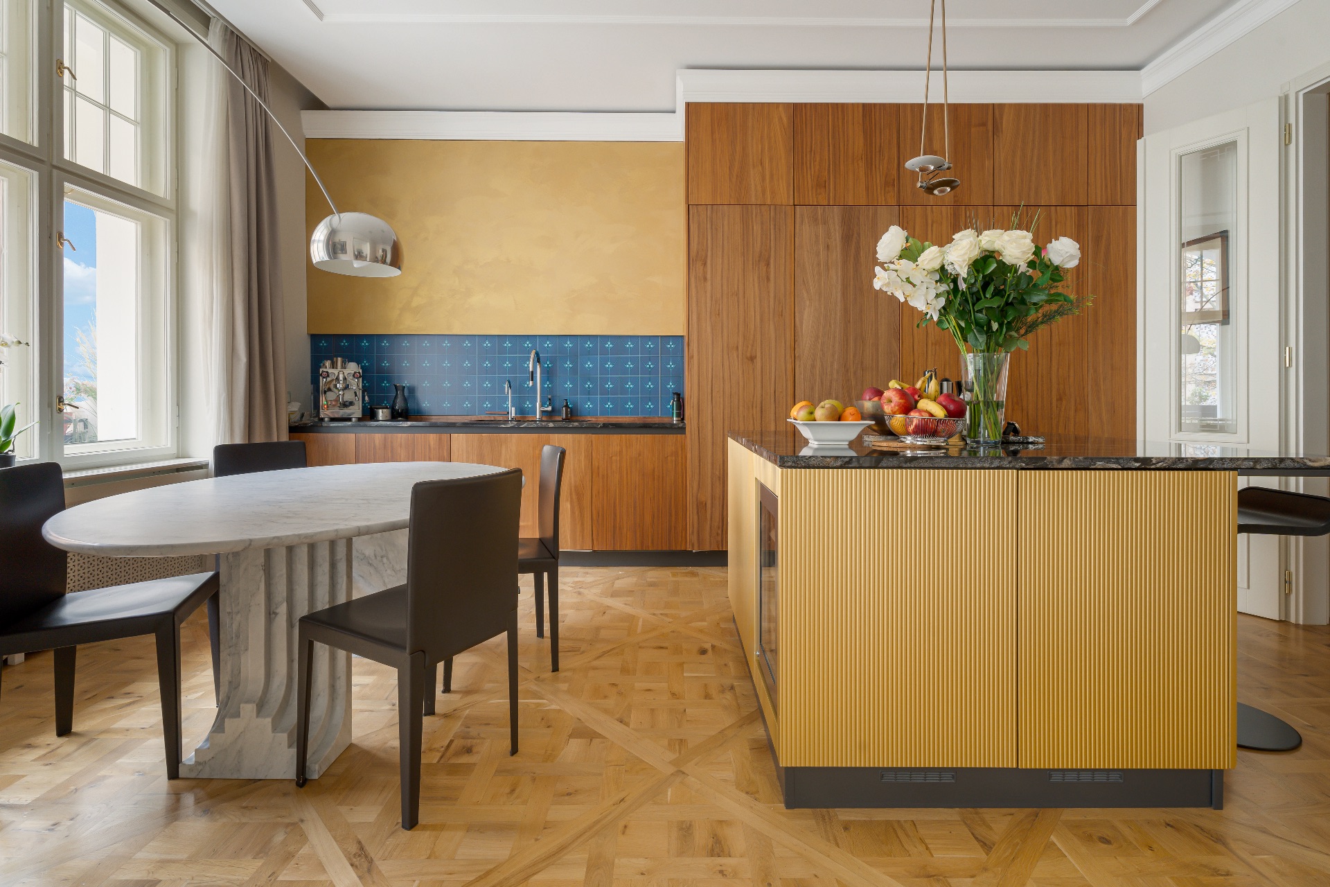 Moderne Küche mit Holzboden, Esstisch, Kochinsel und großen Fenstern.