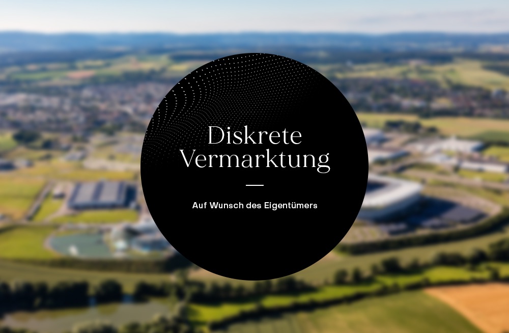 Unscharfes Bild einer ländlichen Umgebung mit Feldern und Gebäuden, Text überdeckt das Zentrum.