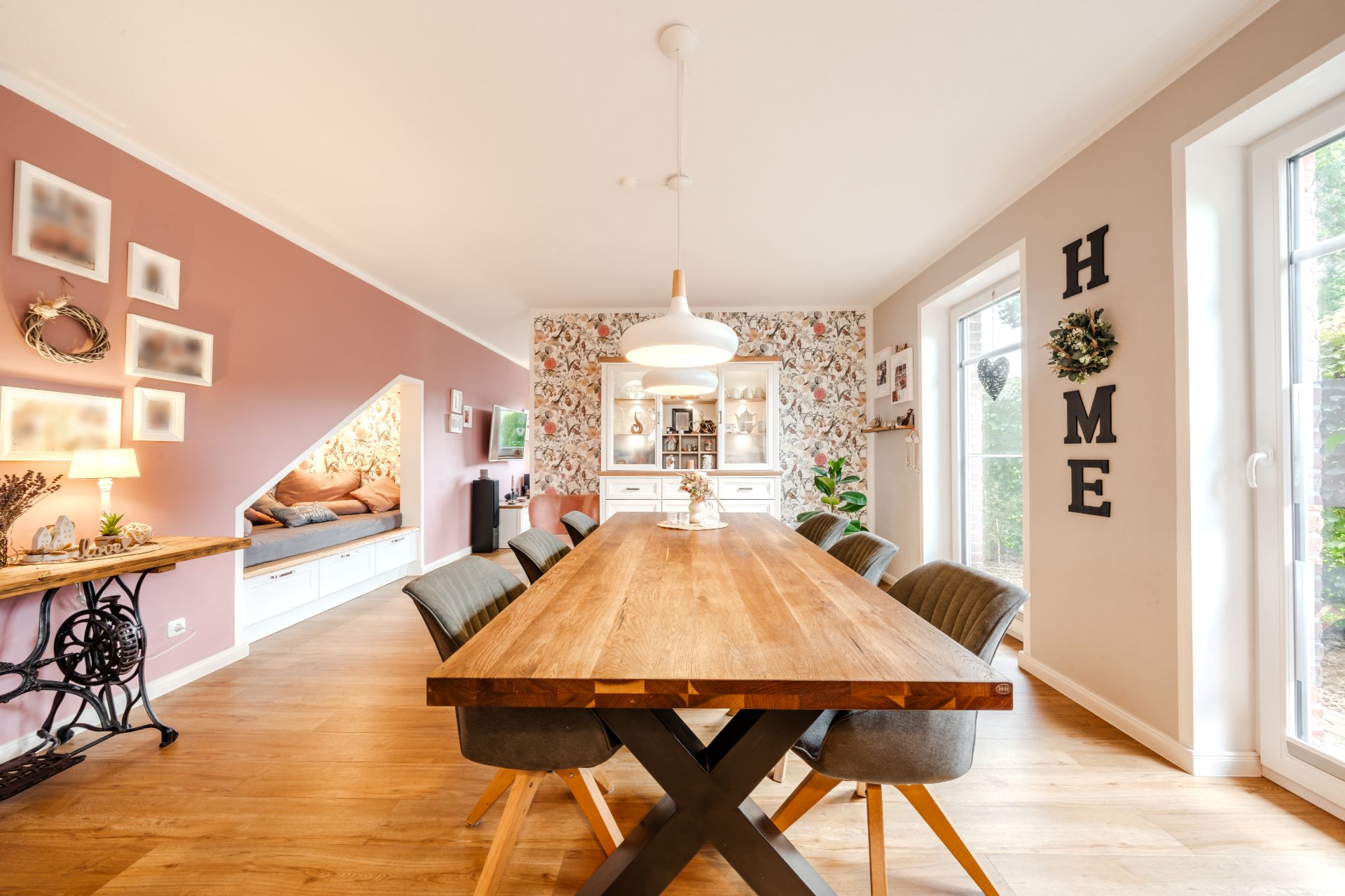 Heller Essbereich mit Holztisch, sechs Stühlen und großem Fenster, gemütlich dekoriert.