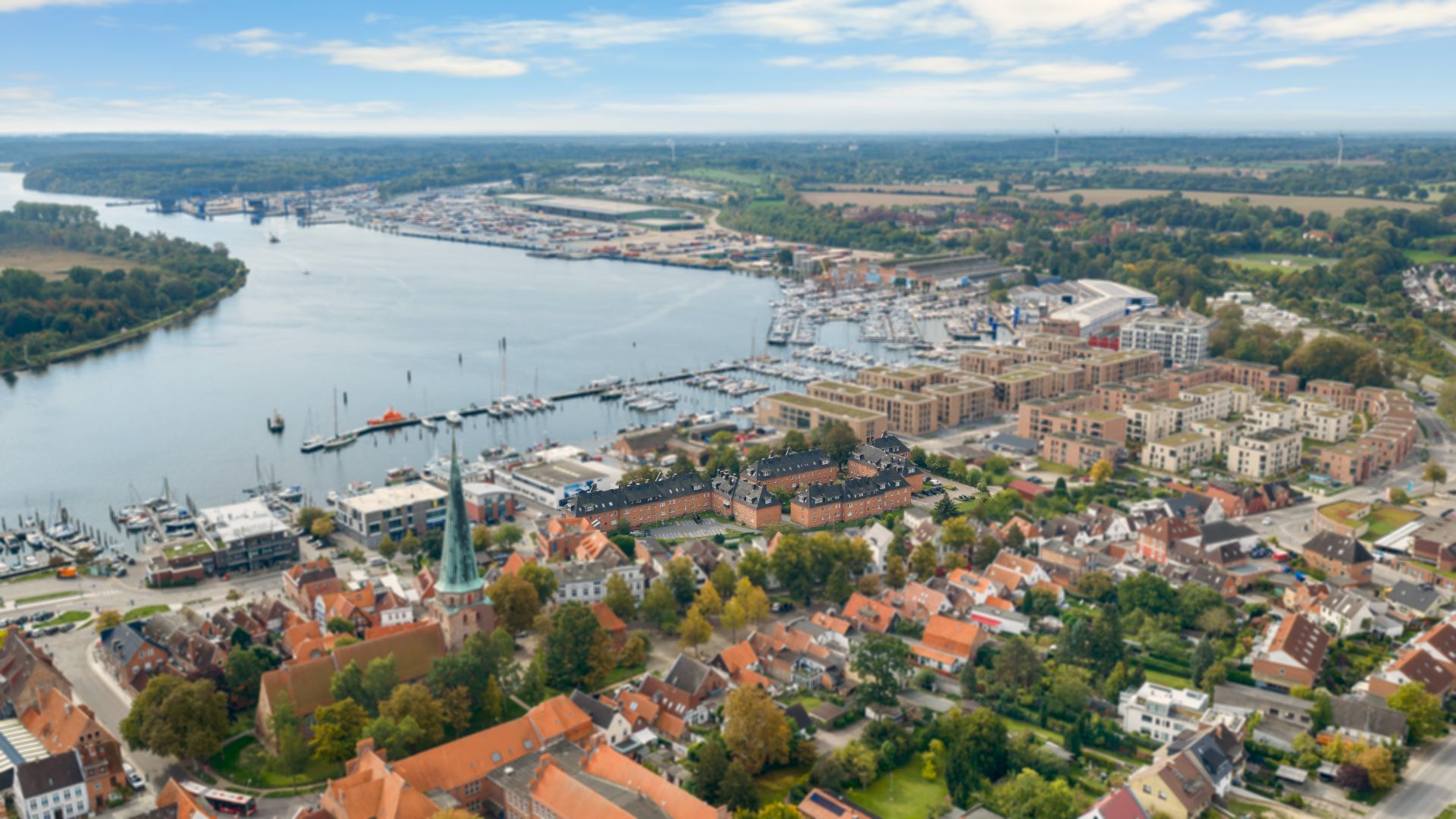 Luftaufnahme einer Wohnsiedlung am Wasser mit vielen Booten und Häusern.