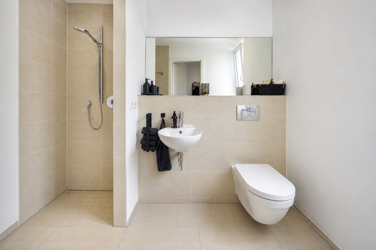 Modernes Badezimmer mit Dusche, Wand-WC, kleinem Waschbecken und großem Spiegel.