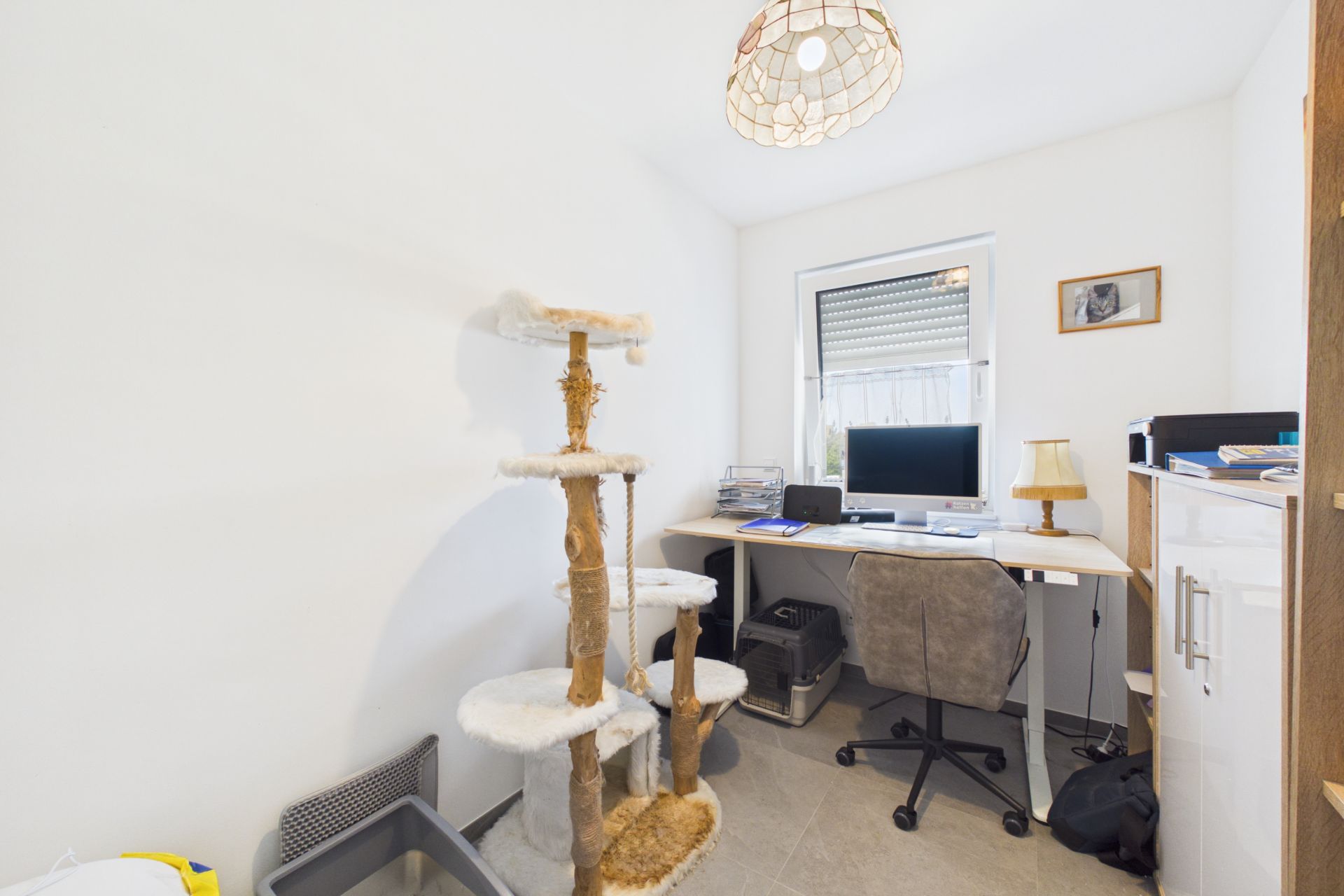 Helles Arbeitszimmer mit Schreibtisch, Bürostuhl, Computer und großem Kratzbaum.