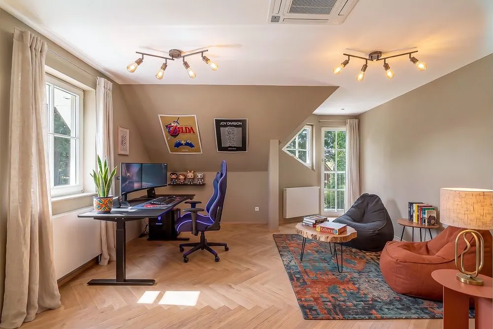 Helles Arbeitszimmer mit Schreibtisch, Computer, Sessel, Teppich und zwei Fenstern.