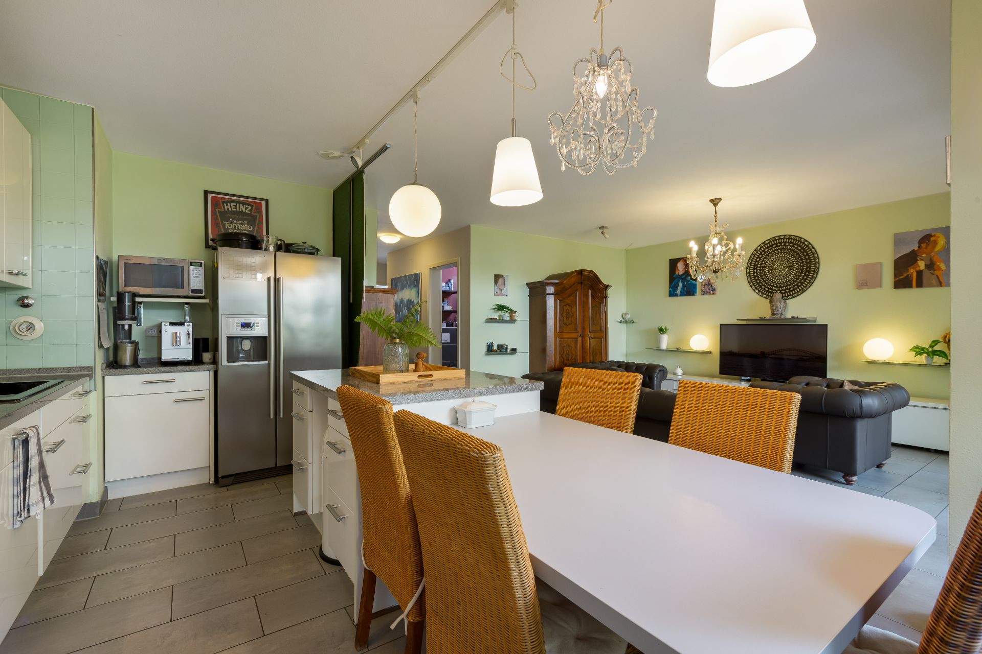Offene Küche mit Esstisch und Wohnzimmer, moderne Einrichtung und Hängelampen.