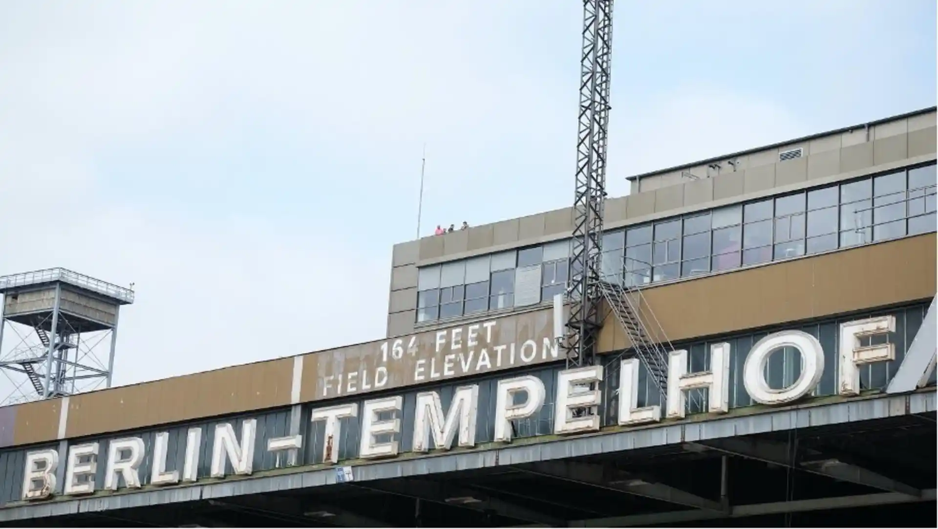 Gebäude mit großem Schild 'BERLIN-TEMPELHOF' und weiteren Schildern darüber.