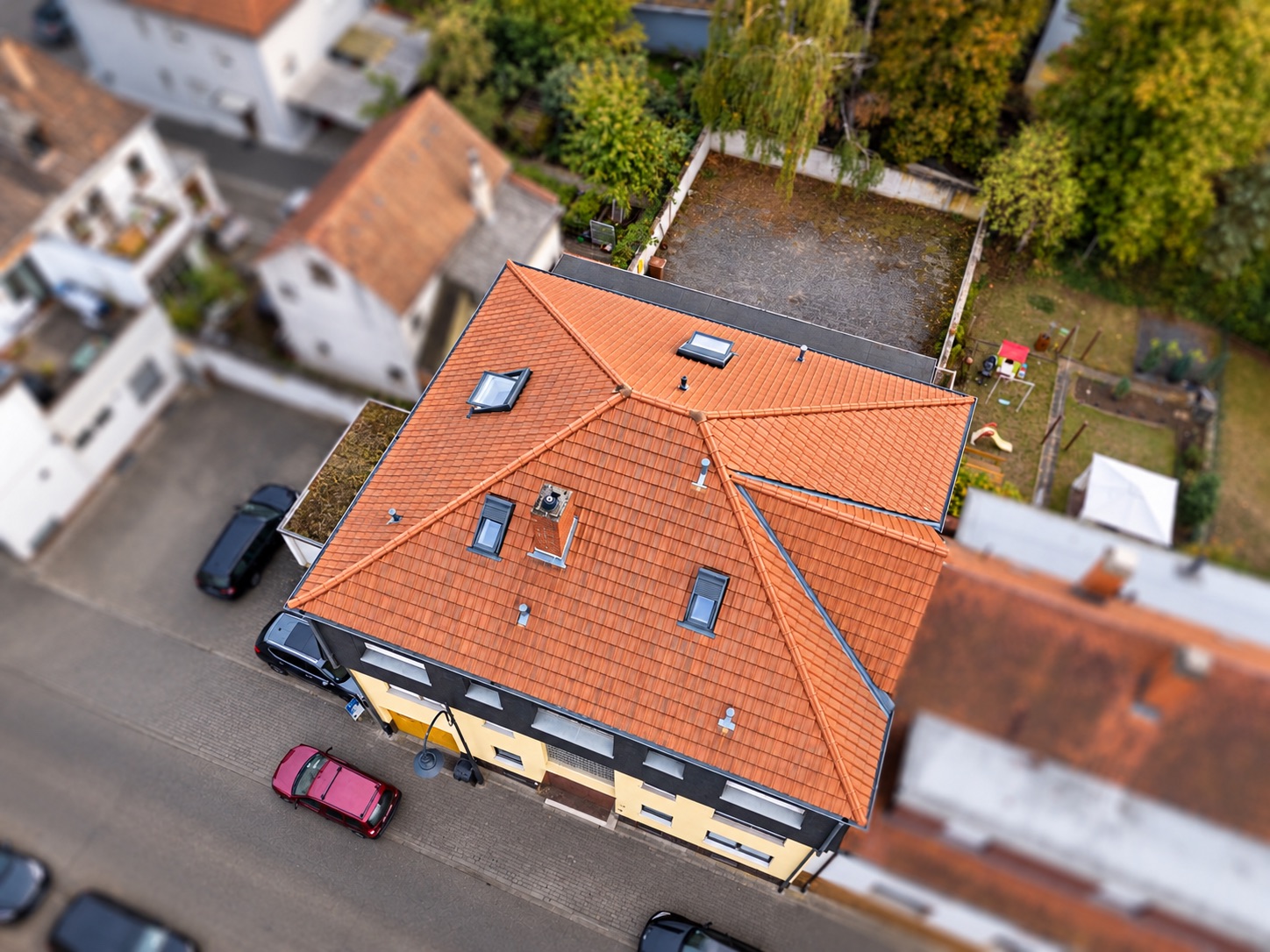 Luftaufnahme eines Wohnhauses mit rotem Ziegeldach und mehreren Dachfenstern.