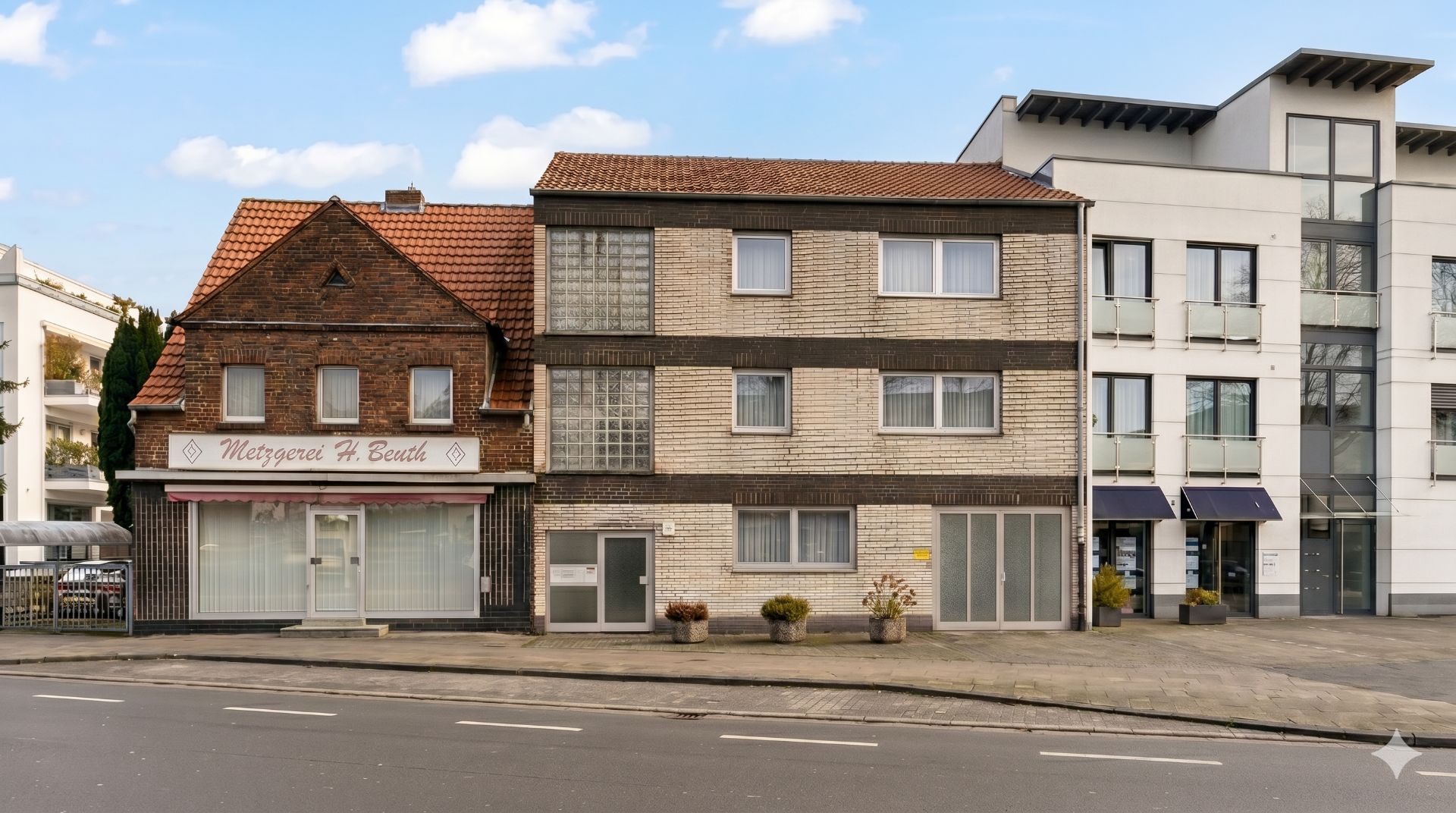 Zwei Wohnhäuser aus Backstein, eines mit Ladengeschäft im Erdgeschoss, an einer Straße.