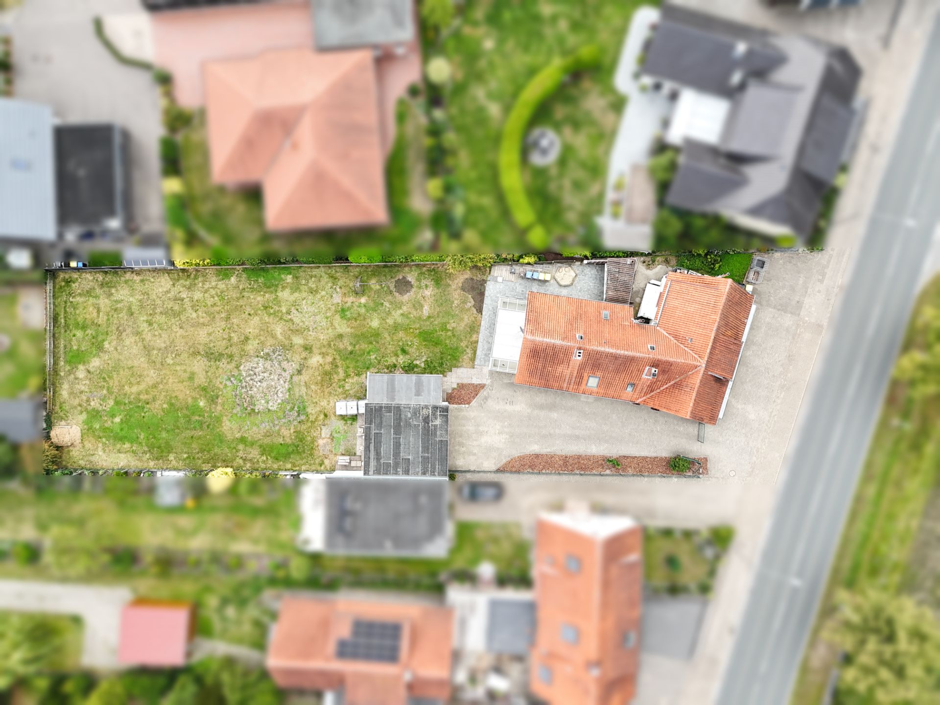 Luftbild eines Grundstücks mit Haus, Nebengebäude und großem Garten.