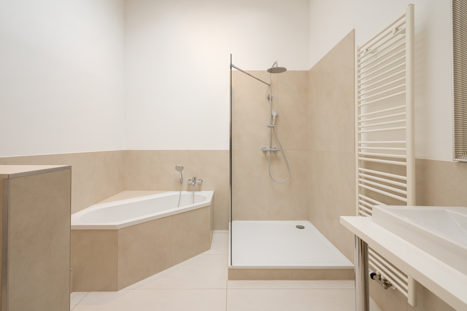 Modernes Badezimmer mit Badewanne, ebenerdiger Dusche und Handtuchheizkörper.
